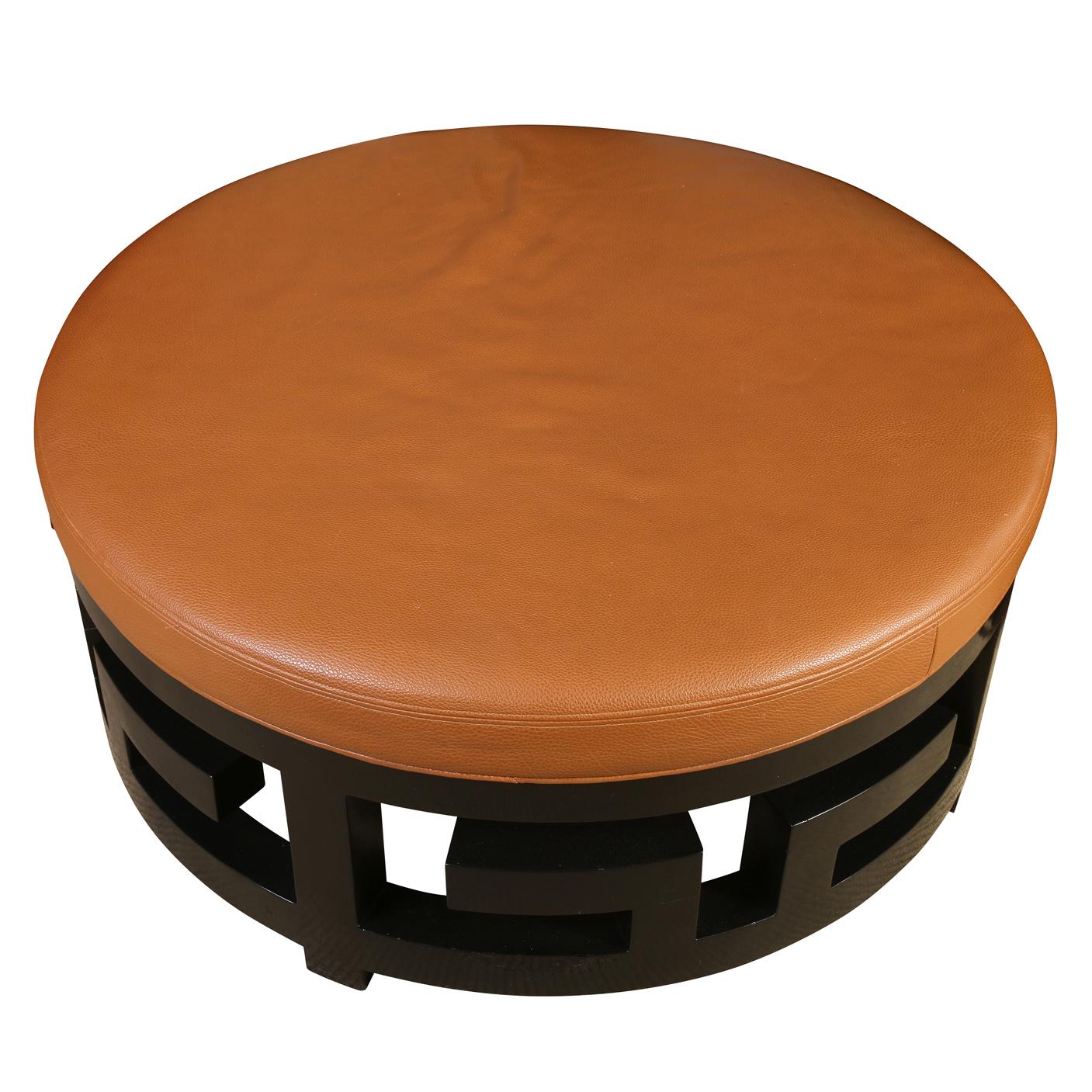 A circular pebbled leather ottoman with a black fretwork base giving it an Asian Modern style. Functional and beautiful both.
