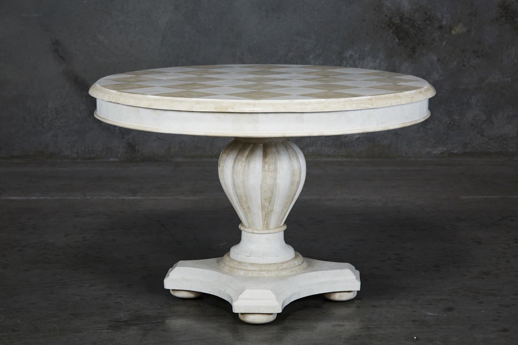 Round dining table fully hand-inlaid with white stone and beige fossil stone. Pedestal base with classical fluted styling, set upon bun feet. Tabletop with Checkered pattern.

All furnishings are made from 100% natural Fossil Stone or Seashell