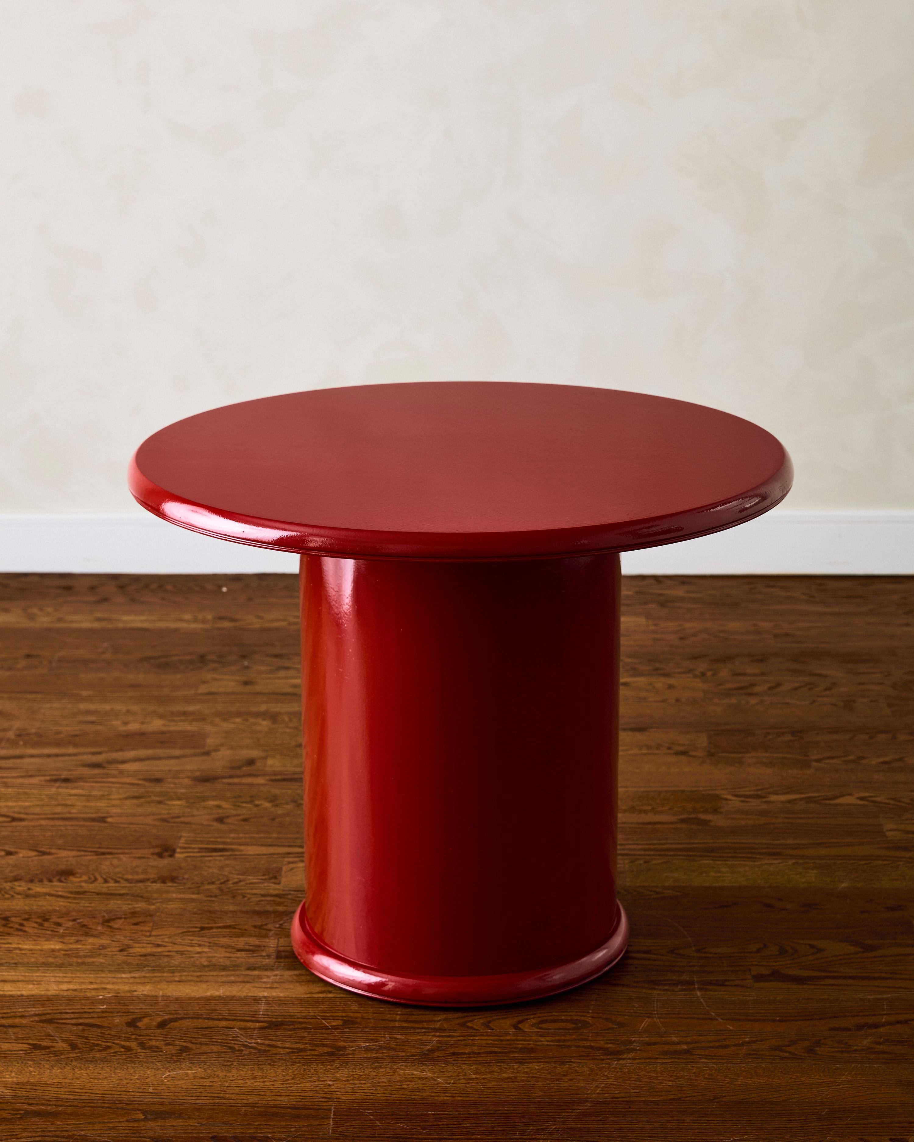 Round pedestal dining table made of wood with red lacquer finish. It can be used as both a dining table and an entry table.

