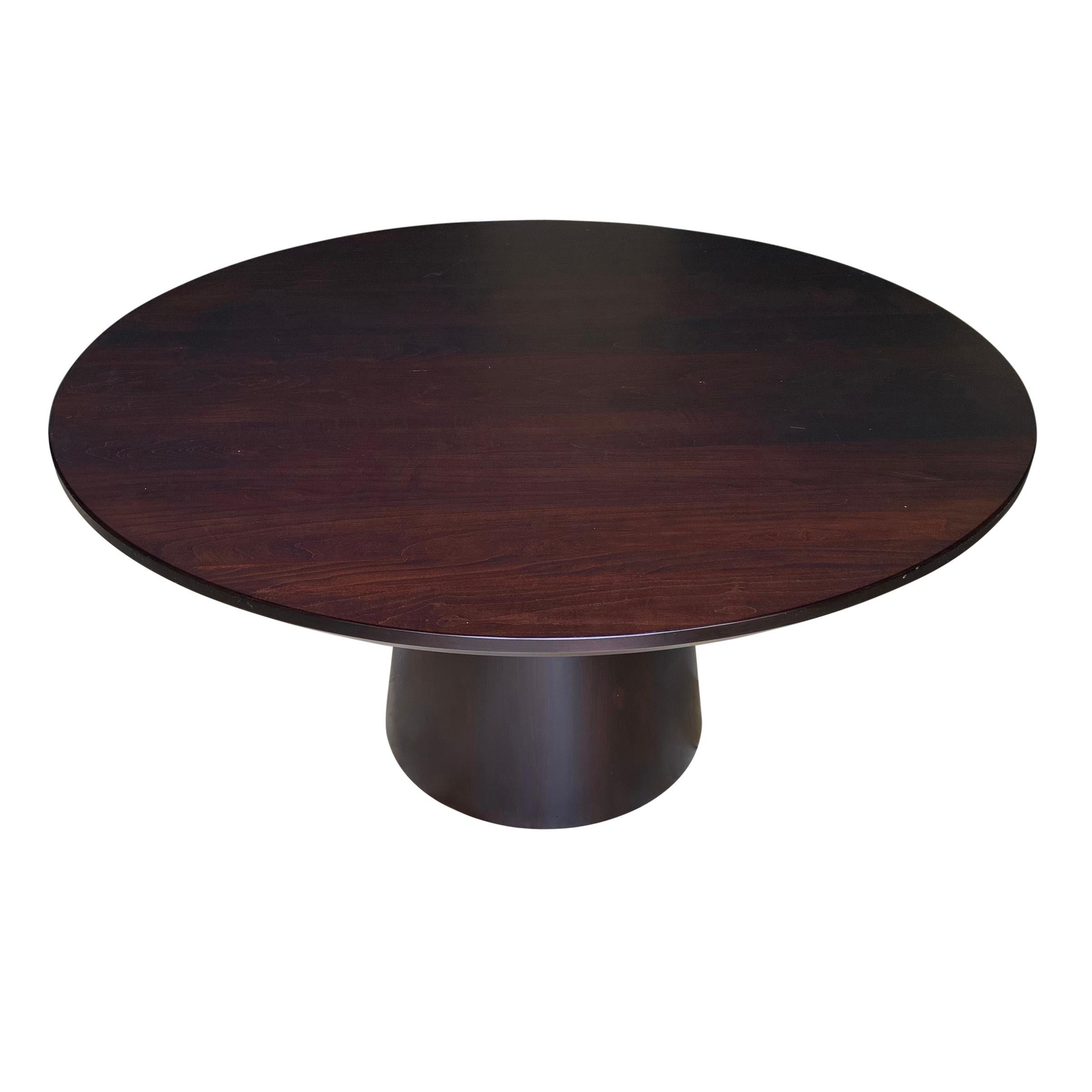 An incredible contemporary pine pedestal dining table with a tapered base, a beveled edge top, and a dull matte finish. There are natural 