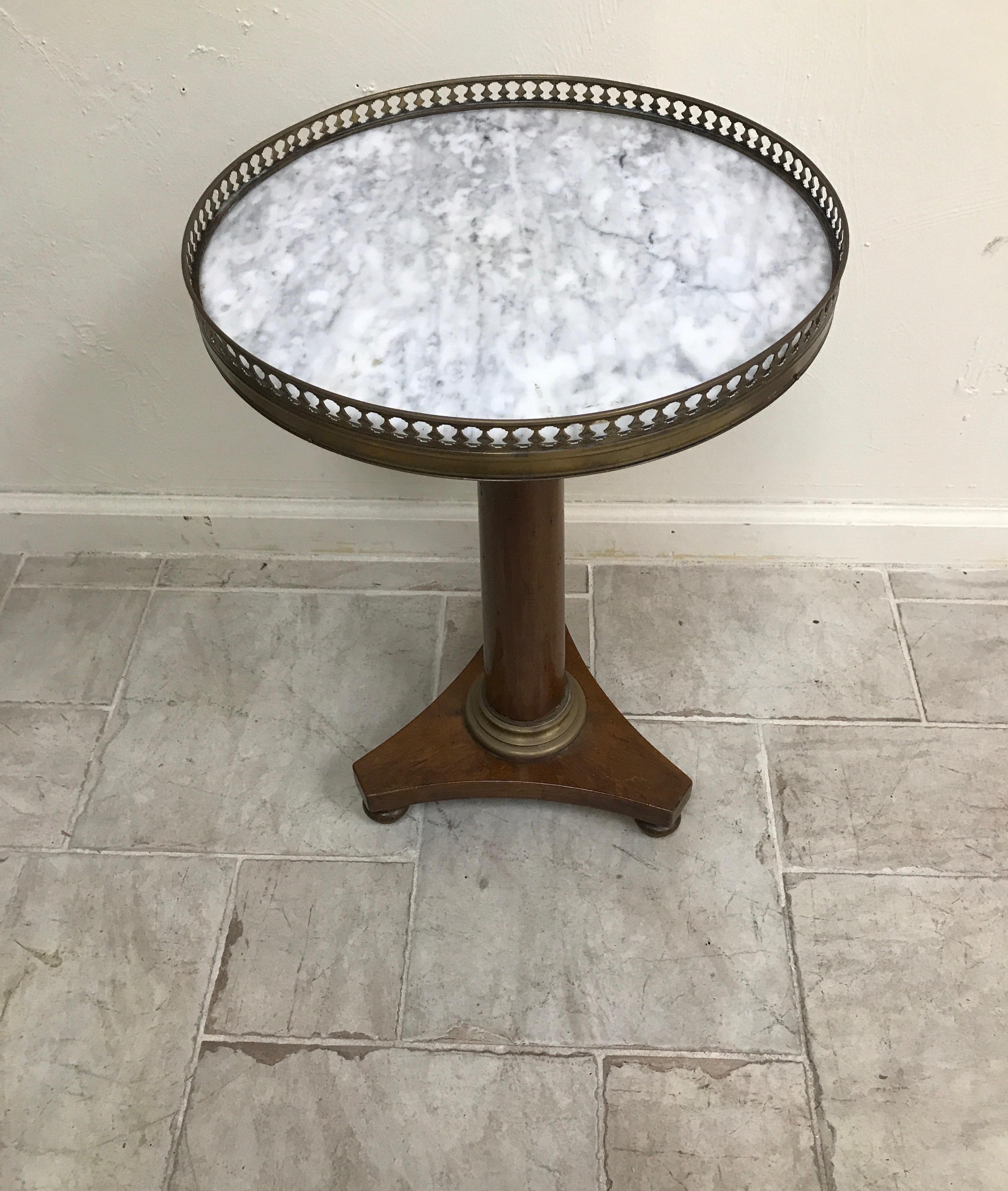 Round galleried pedestal drinks table with white/grey marble top.