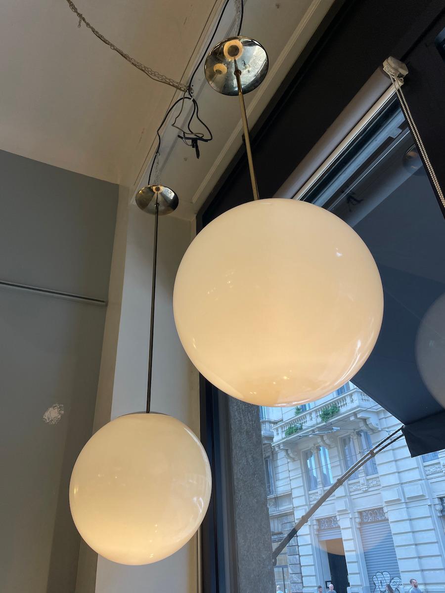 Lampes suspendues sphériques des années 1970. Au total, 13 pièces sont disponibles en différentes tailles. Le bras porteur est en laiton et varie en hauteur, ce qui permet des compositions ludiques et dynamiques lors de l'utilisation de plusieurs