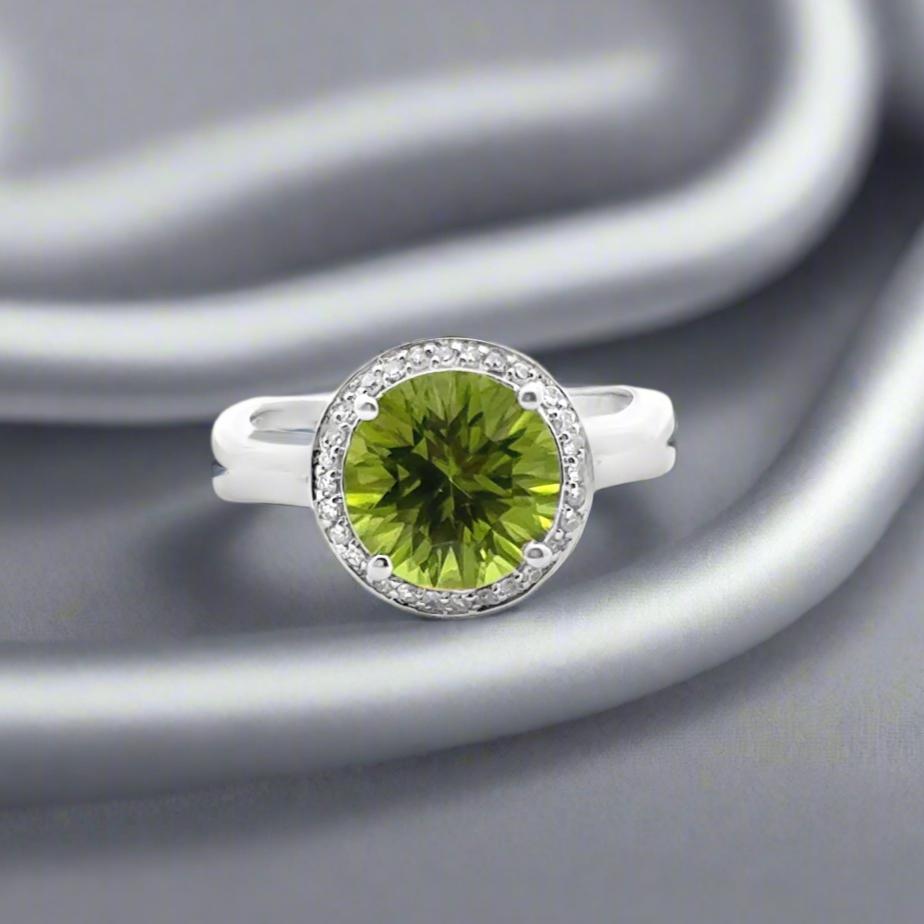Este impresionante anillo de cóctel de oro blanco de 14 quilates presenta un vibrante peridoto redondo de 2,93, acentuado con diamantes naturales. El gran peridoto muestra su color brillante, mientras que los diamantes añaden un toque de elegancia.