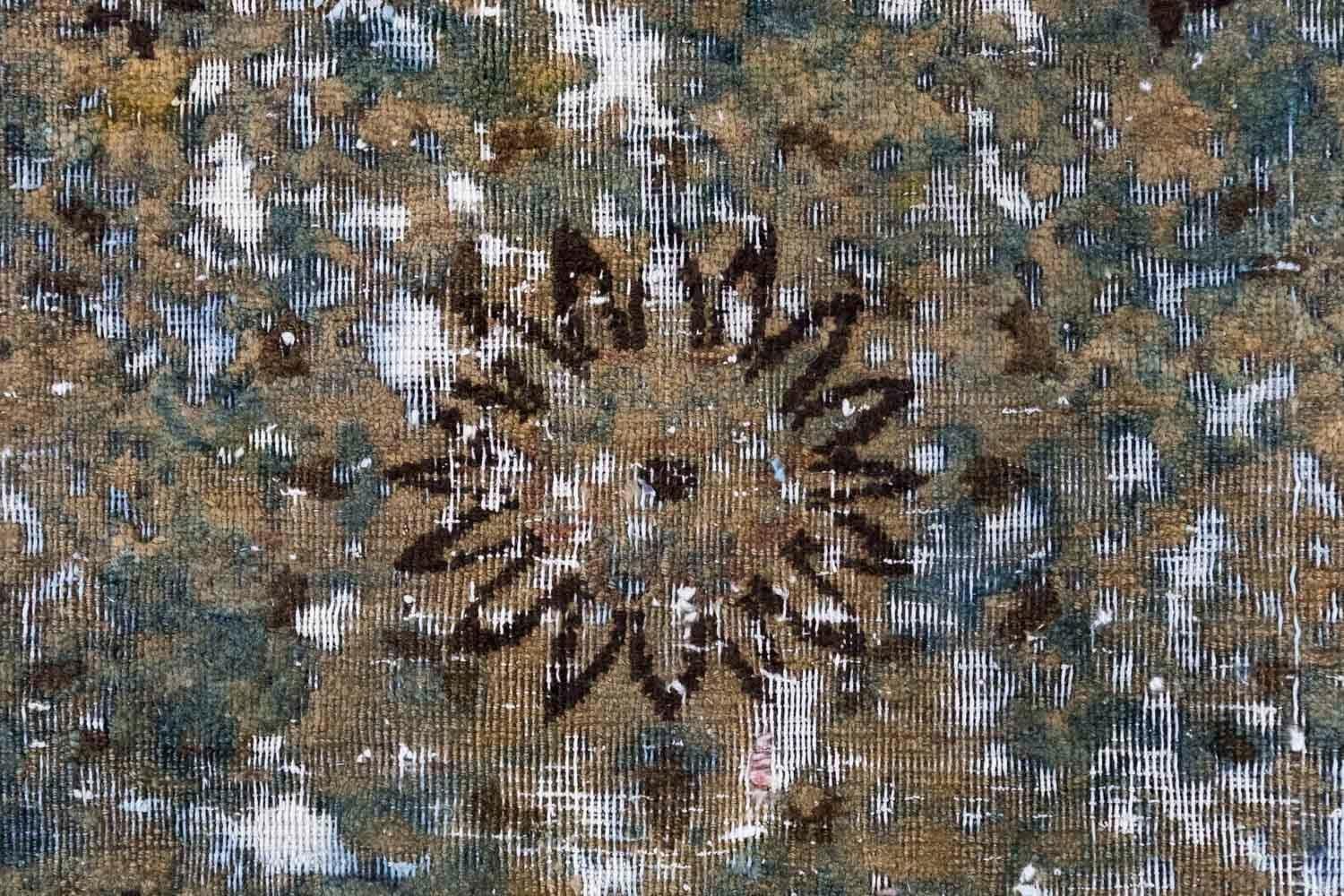 Old round Persian carpet in brown and green shades with a central motif of stylized flowers and scattered motifs of rosettes.
Carpet texture gained thanks to an artist’s contemporary work by mowing, scratching and tint.

Unique piece.