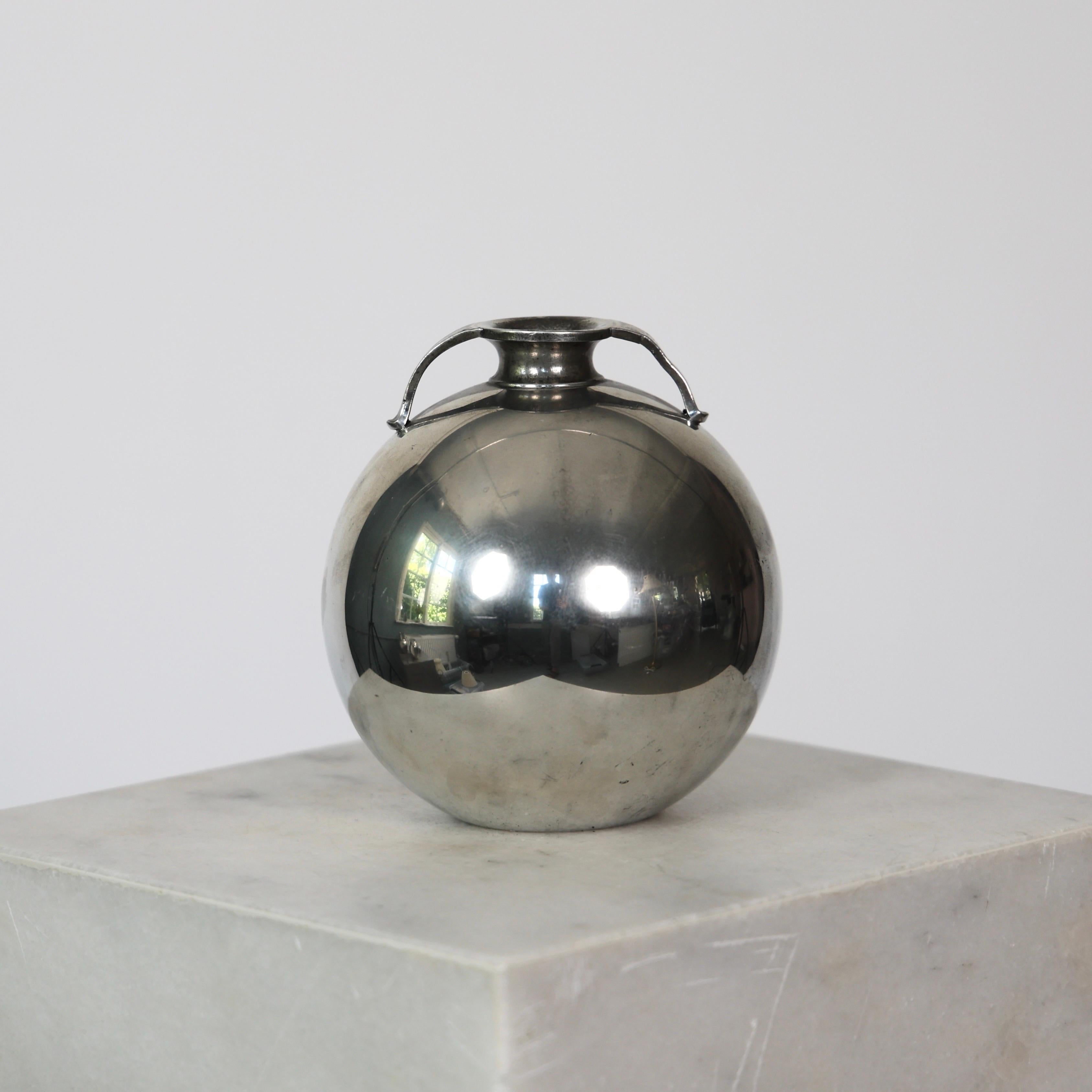 Elegant Round Pewter Vase made by Just Andersen in the 1930s.

* Round pewter vase with lugs
* Designer: Just Andersen
* Style: 1662 (stamped ‘Just 1662’)
* Year: 1933
* Condition: Fair vintage condition. Makers engraving intact. Small marks and