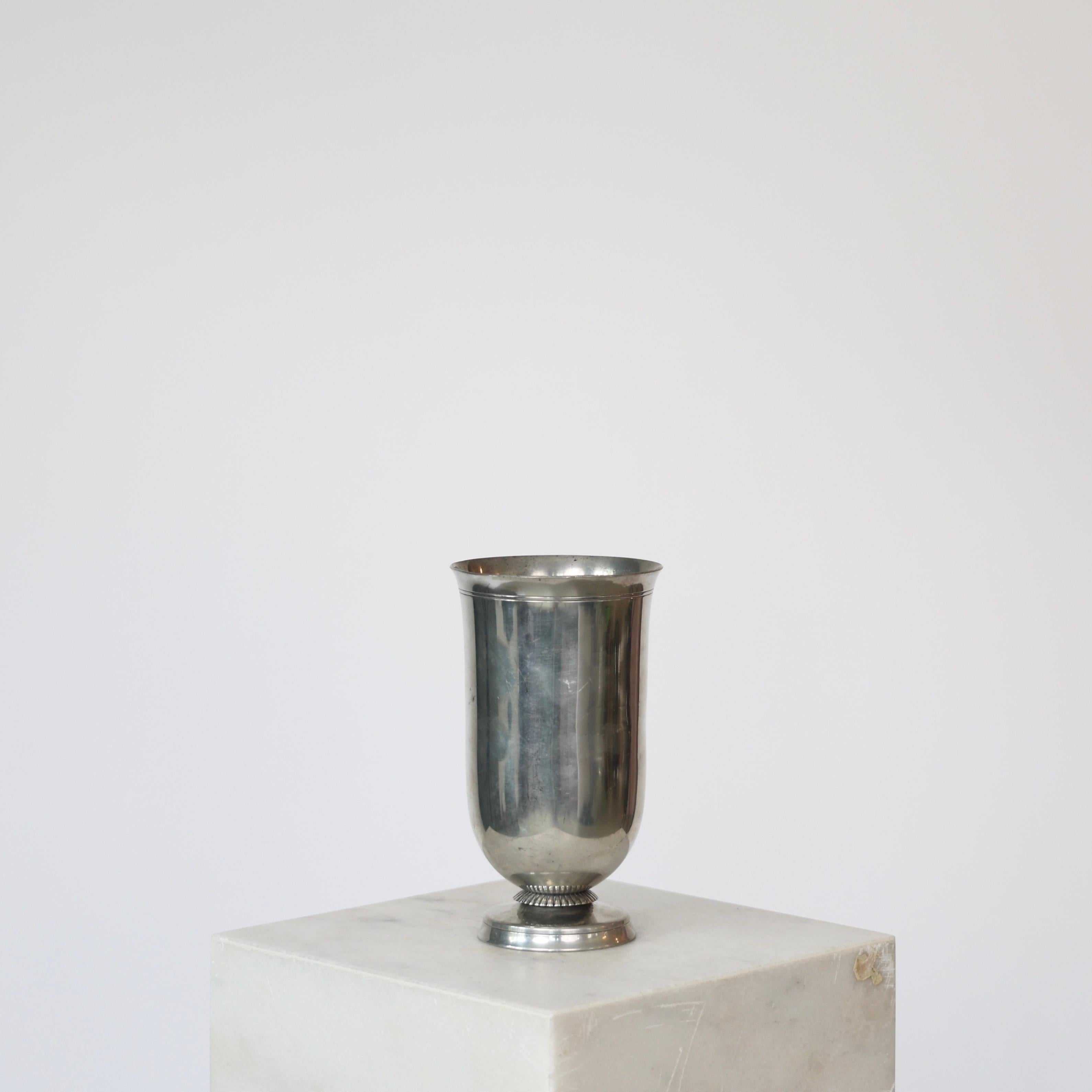 Vaso rotondo in peltro su piede realizzato da Just Andersen negli anni '30.

* Vaso rotondo in peltro su piede.
* Designer: Just Andersen
* Stile: 1728 
* Anno: 1935
* Condit: Discrete condizioni vintage. Incisione del costruttore intatta. Piccoli