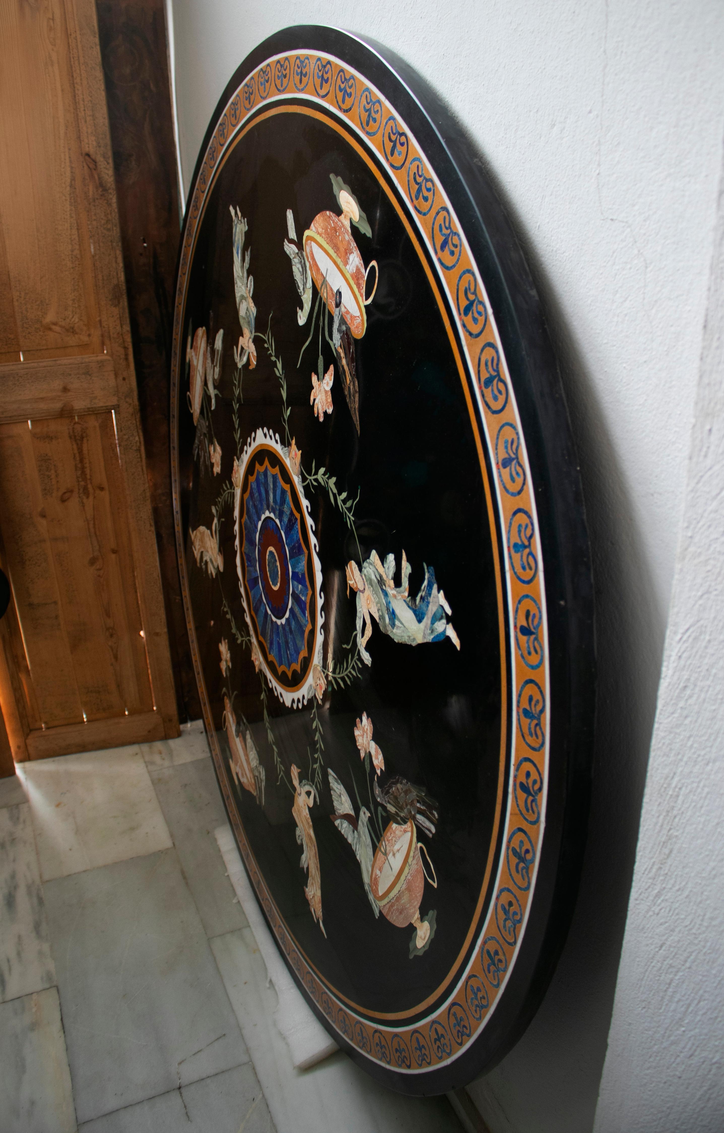 Round Italian pietre dure technique handmade black marble mosaic tabletop with Greek scenes composed with blue lapis and other semiprecious stones inlay.