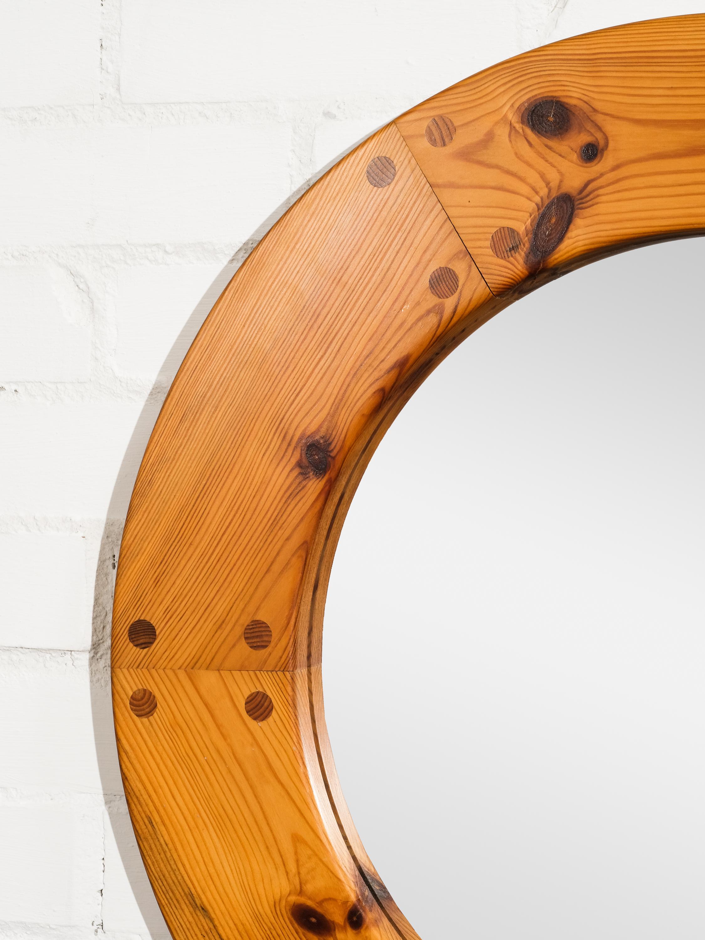 A solid pine round wall mirror designed by Uno Kristiansson and produced by Luxus, Sweden, 1960s.