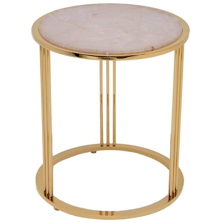 This refined side table inspired by Greek mythology combines natural materials with a sophisticated silhouette for a striking appearance. The top is a round piece of cut Brazilian rose quartz, believed to be a gift from the god Eros to help attract