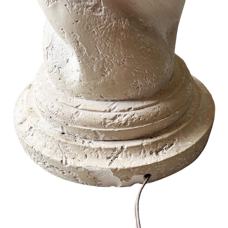 A tall post modern circular plaster 1970s spiral floor lamp in the manner of Michael Taylor. This large lamp is created from a creamy white plaster and features a swirled look around its tall body. It is round and has a button switch. Lighting can