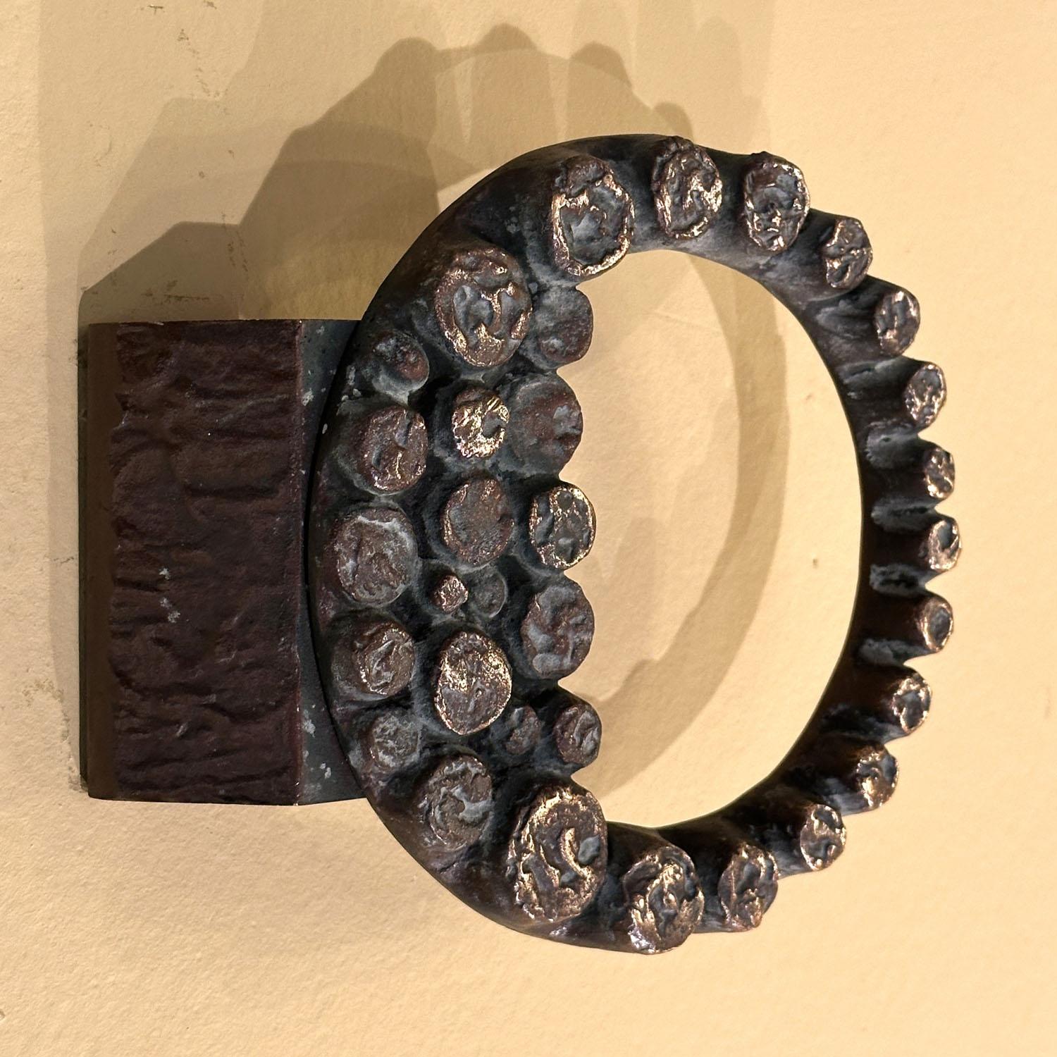 Single round door handle with relief ring that is deeply textured like the tentacles of an octopus. Cast bronze relief in perfect condition. The bronze has a subtitle patina due to the textured surface and its age, circa 1970's. 
Artistic door