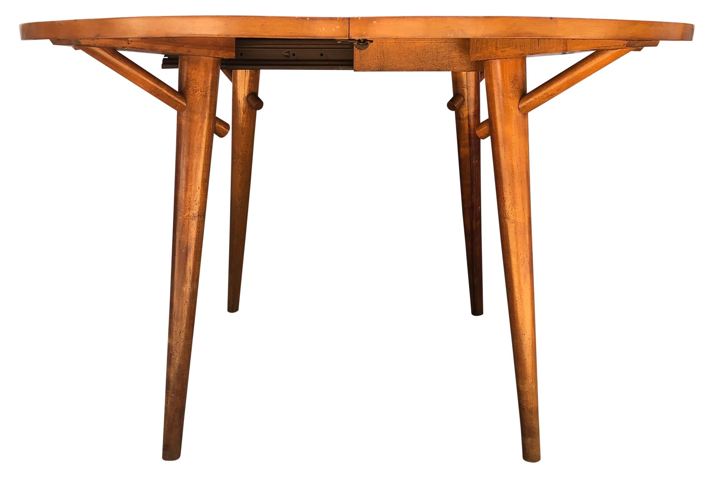 Beautiful early 1950s round rare Leslie Diamond maple dining table with 2 leaves by Conant Ball, great midcentury design. Very sturdy designed dining table #6008 with tapered legs. Solid maple table with a blonde stain. (2) Original table leaves (1)