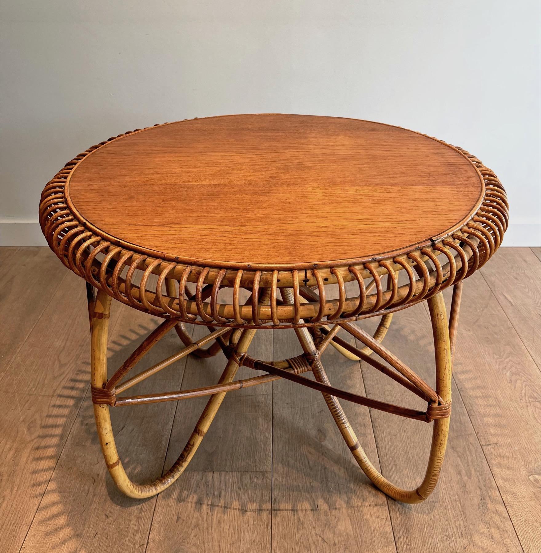 Cette très belle et inhabituelle table basse ronde est faite d'un très beau travail de rotin avec un plateau en bois. Il s'agit d'une œuvre italienne dans le style du célèbre designer Franco Albini. Circa 1950