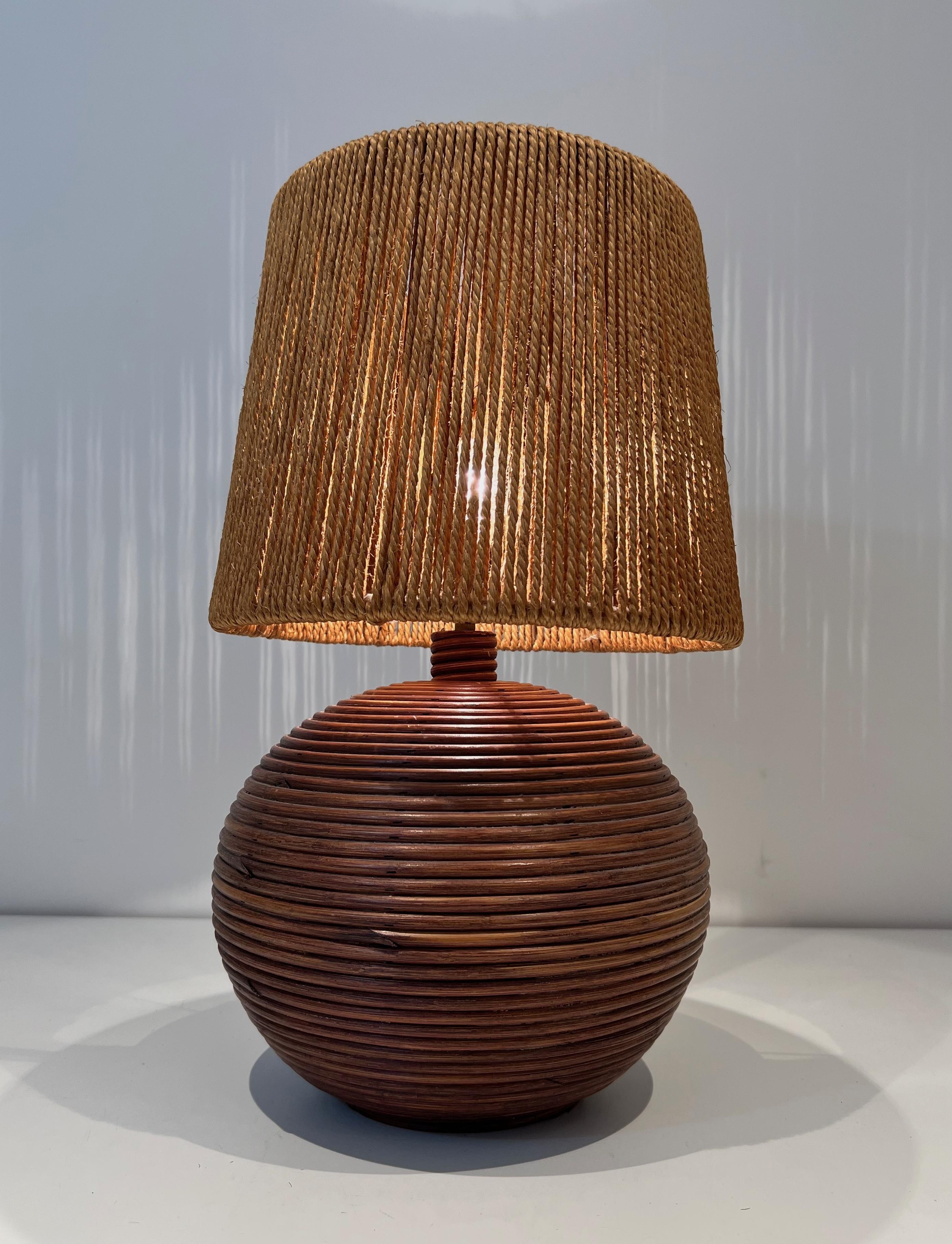 This very nice round table lamp is made of a rattan base with a rope shade. This is a French work in the style of Adrien Adoux and Frida Minet. Circa 1970