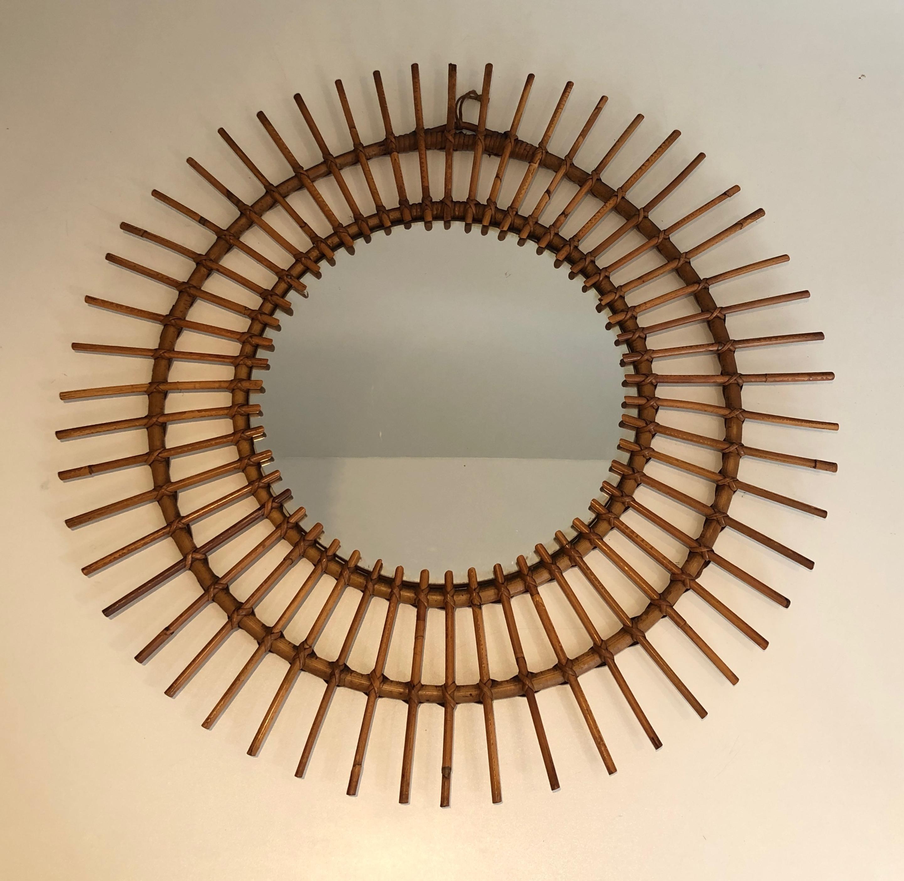 Dieser runde Spiegel ist aus Rattan gefertigt. Es handelt sich um ein französisches Werk aus der Zeit um 1950.