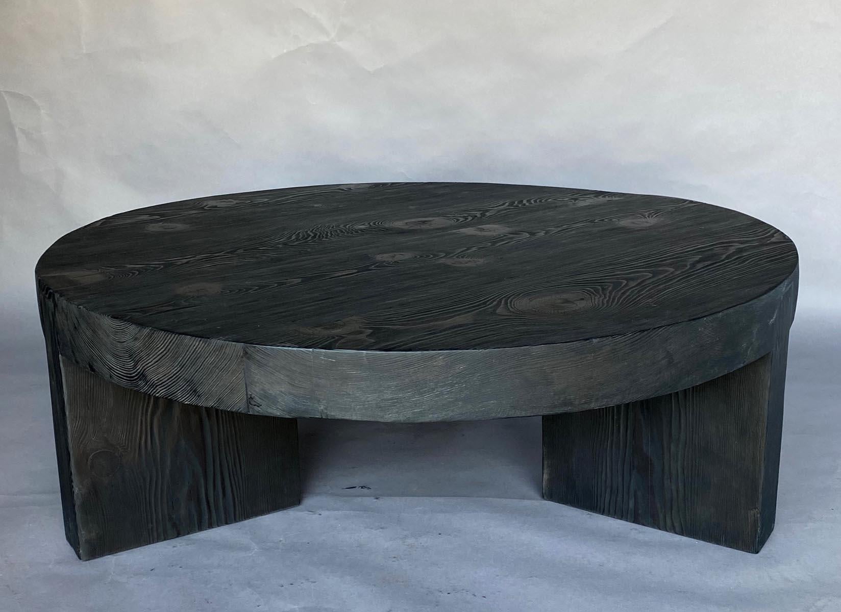 Rustic modern round coffee table with three legs made in reclaimed Douglas Fir and finished in black matte . Top and legs are all 3.5 inches thick. This rustic, modern 43 inch diameter cocktail tables is substantial and striking.