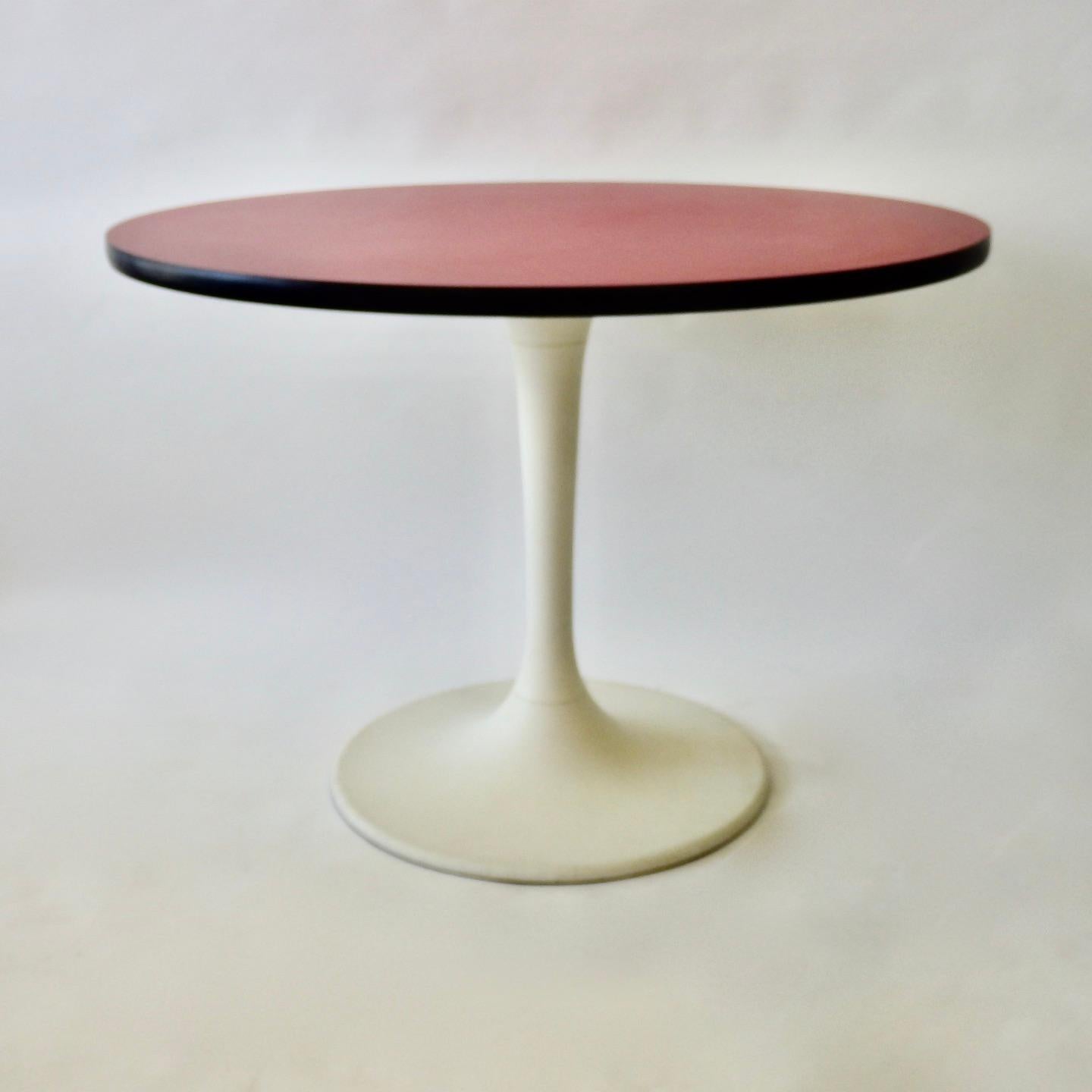 Followinf suite to Eero Saarinens tulip tables for Knoll. Maurice Burke designed a number of variations on that theme. This one has a red top with milky white base.