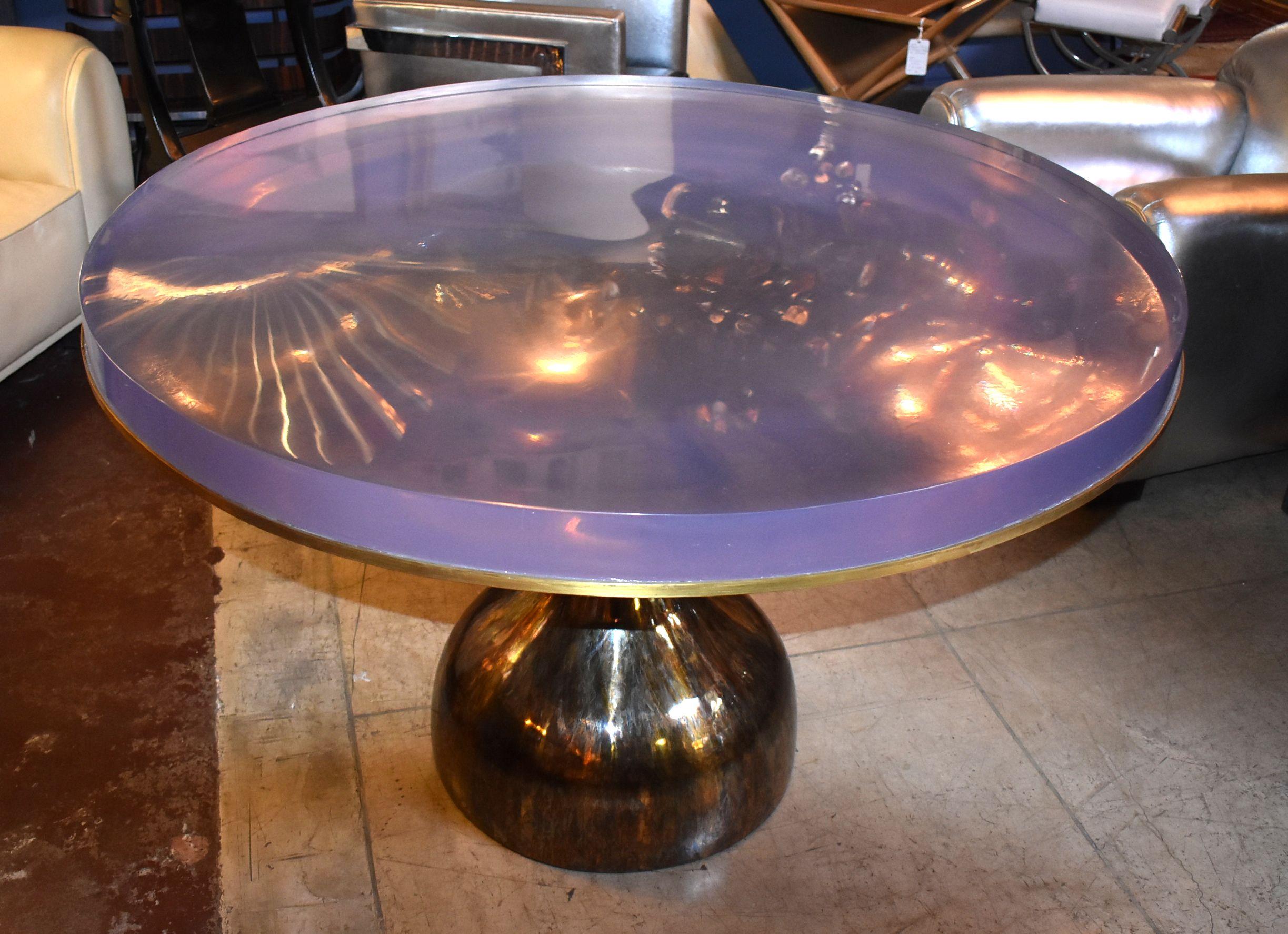 Thick resin top round table in tortoise brass finish base.