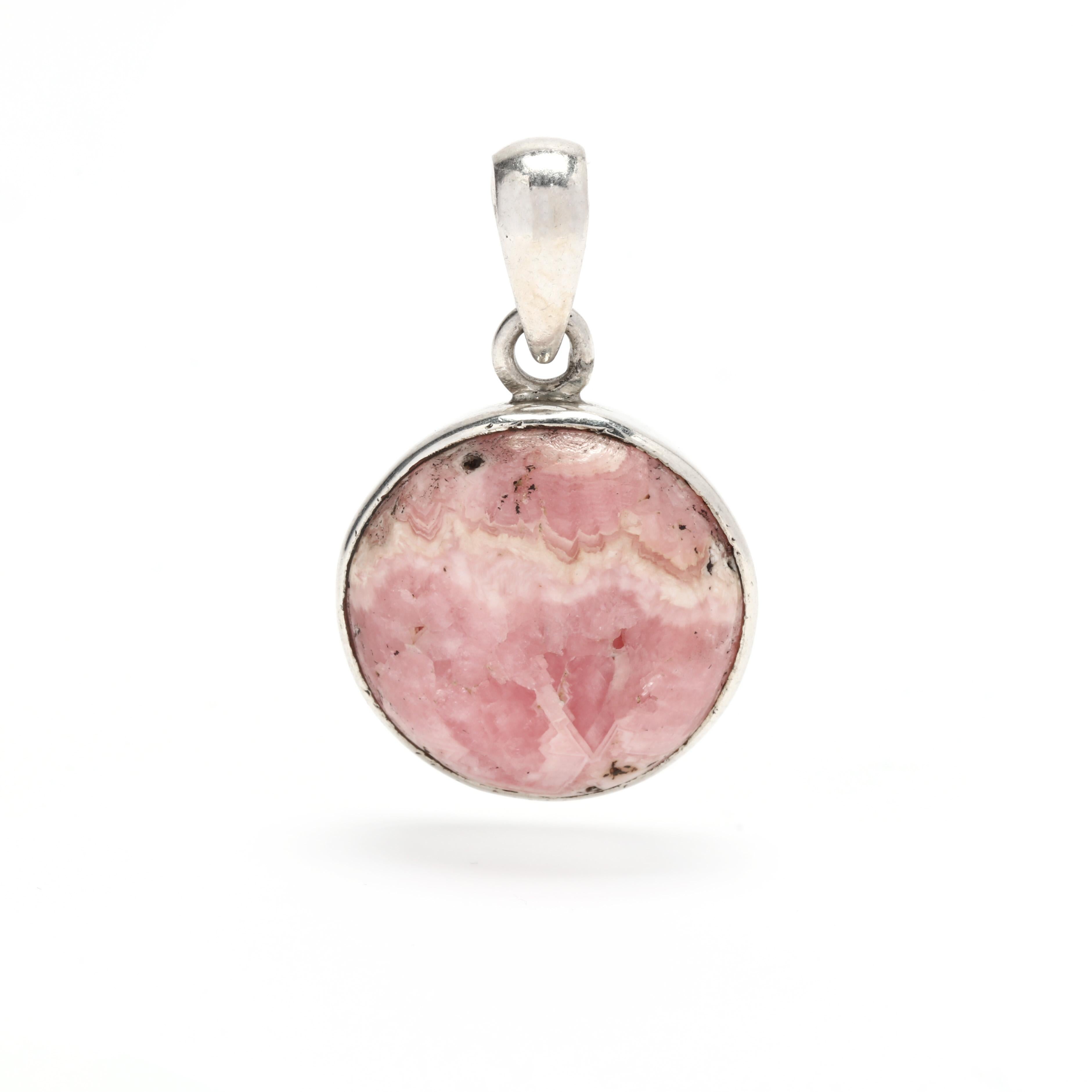 This stunning Rhodochrosite Pendant is the perfect accessory to add a touch of elegance to any outfit. Handcrafted from sterling silver, this 1 1/8 inch round pink pendant is the perfect circle shape. The unique pink hues of the Rhodochrosite will