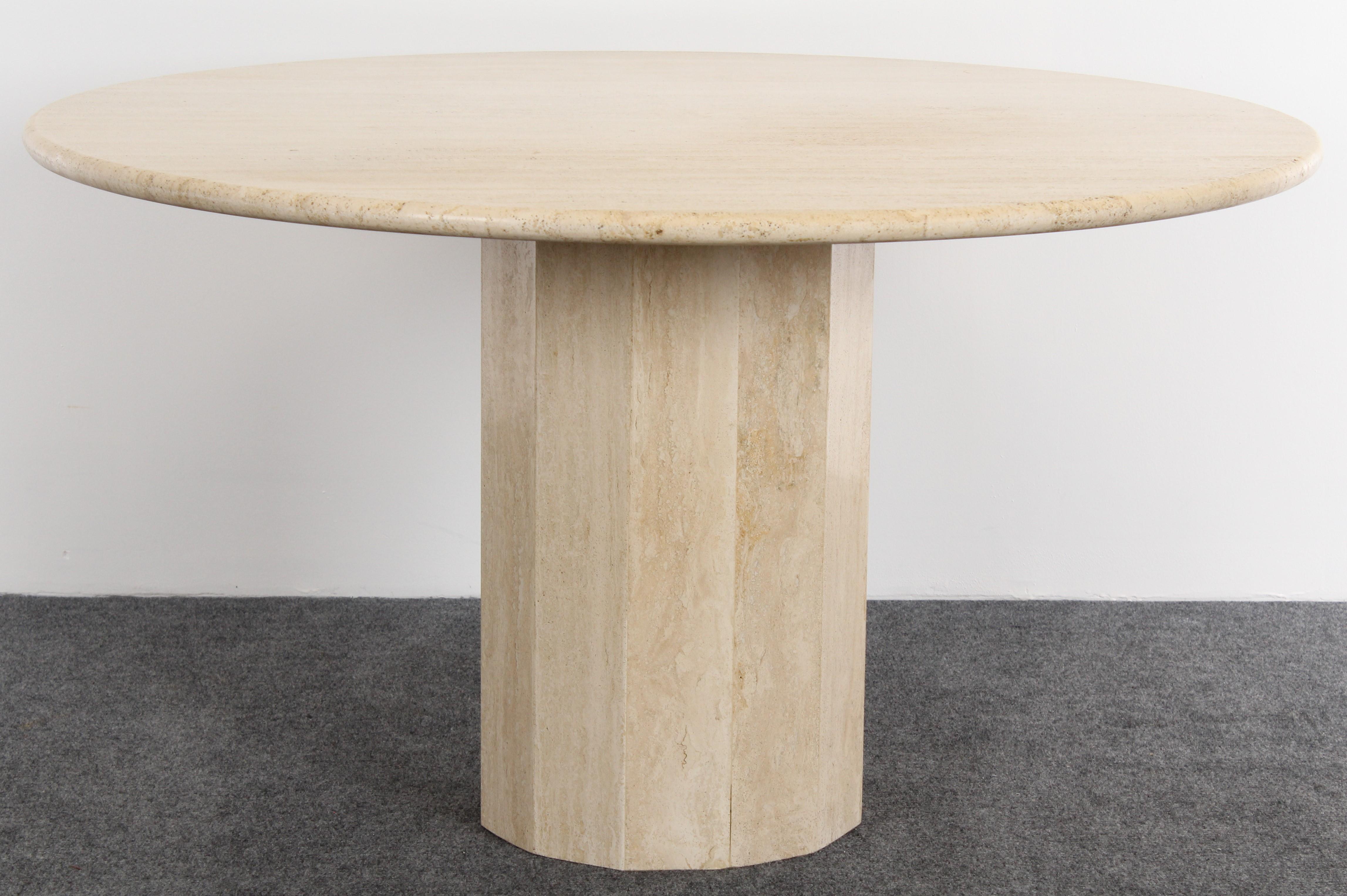 A Classic Mid-Century Modern round Roche Bobois Style Italian travertine dining table on a trapezium pedestal base, 1970s. The table has a simple rounded bull nose edge. Good condition with age appropriate wear.