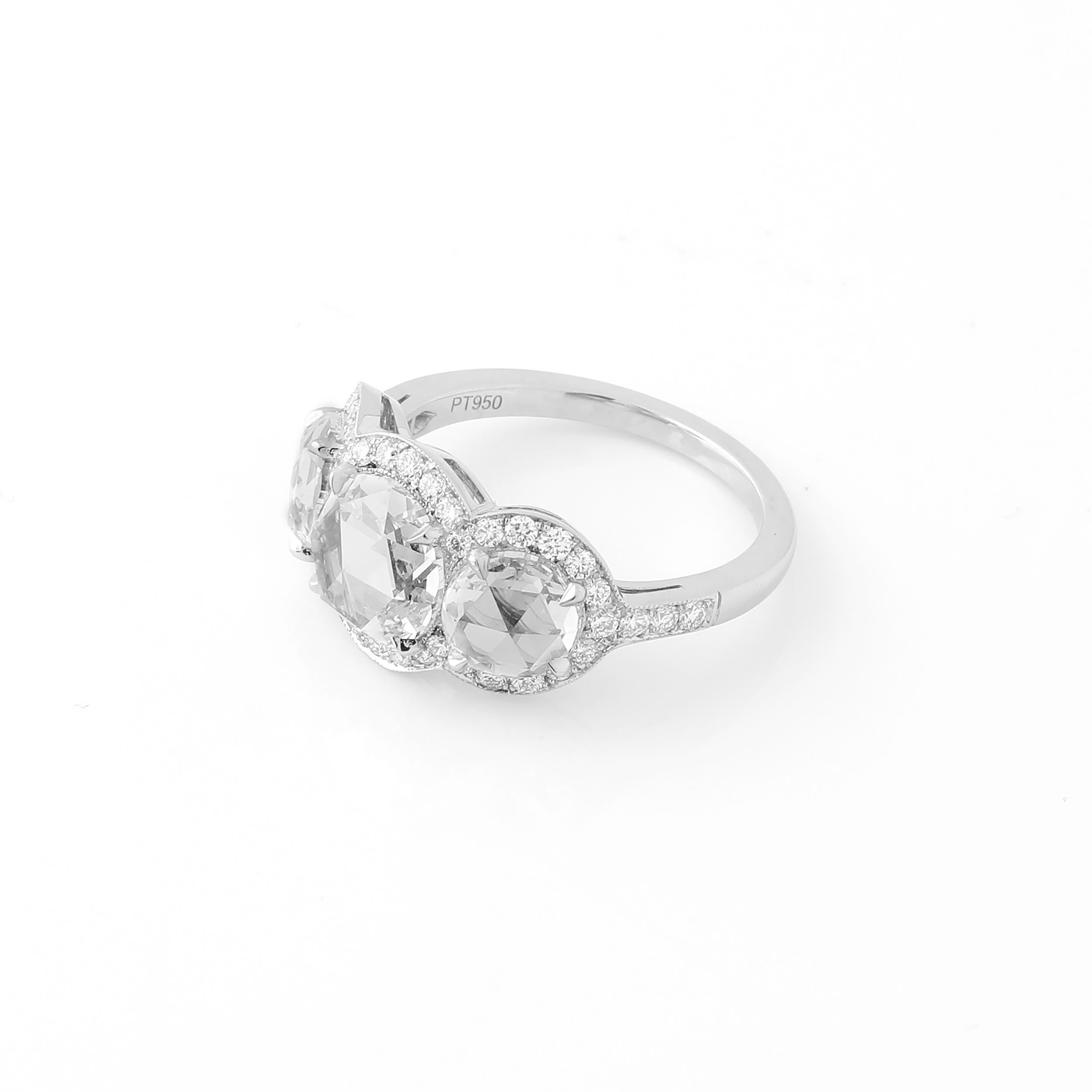 This ring features a 1.51 carat rose cut round diamond at its center, and a pair of beautifully matched rose cut rounds weighing 1.40 carats as side stones. The diamonds are not certified, but are 100% natural and approximately G-H color and VVS