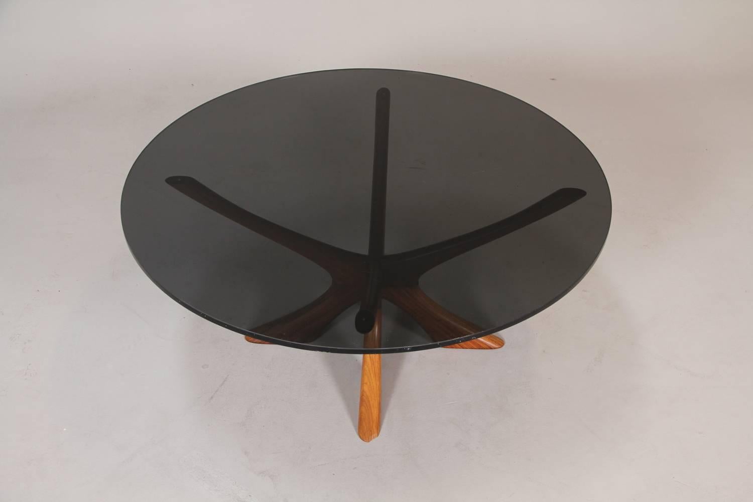 Designed by Illum Wikkelso and made by Silkeborg, thi round rosewood side table was made in Denmark during the 1960s. The rosewood base carries a smoked-grey colour glass top. The table with is 41cm high and 94.5cm in diameter. 

There are a few