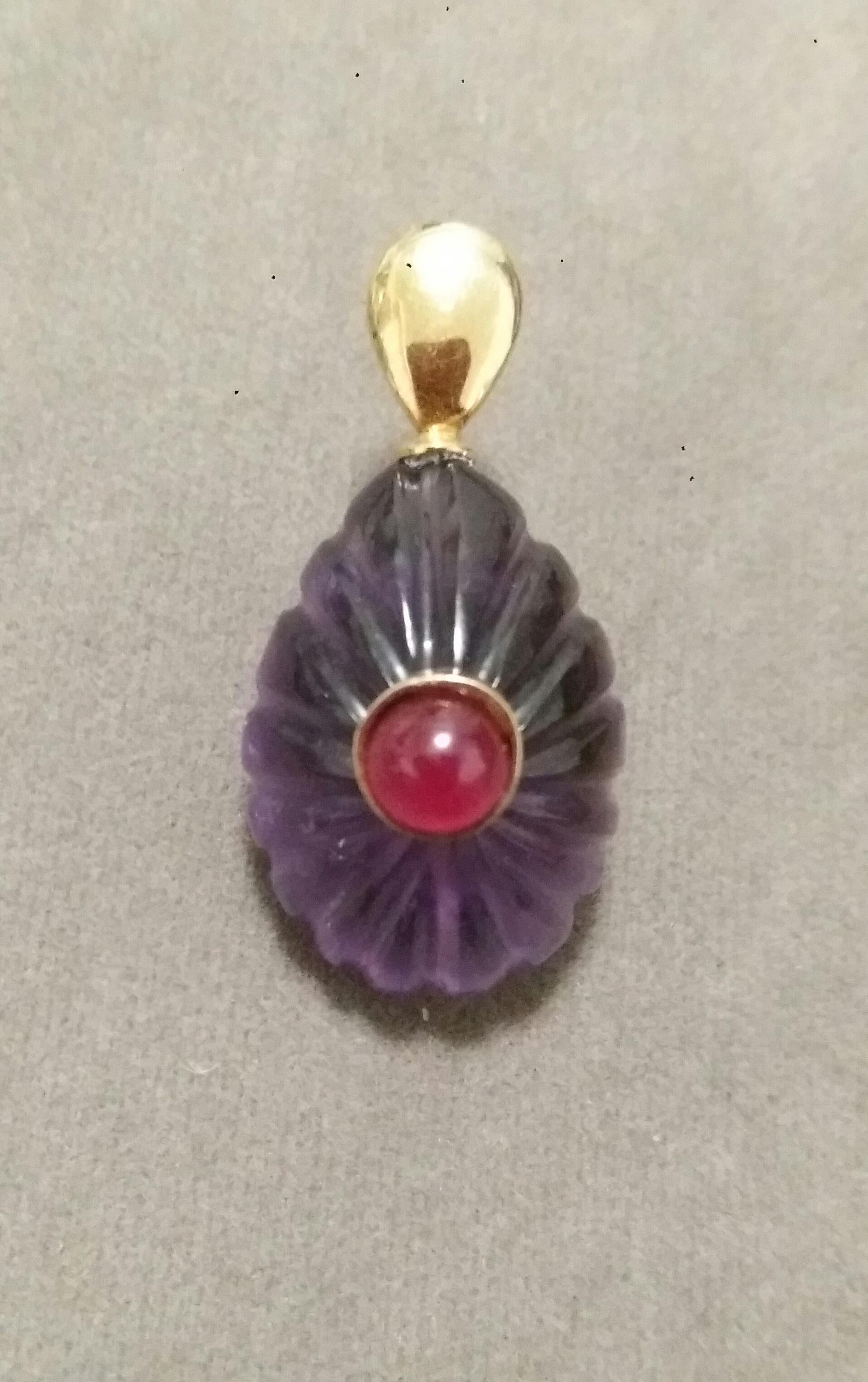 Simple chic Engraved Pear Shape Amethyst pendant measuring 16mm x30 mm set in solid 14 Kt. yellow gold hook and with a Round Shape Plain Ruby Cab  in the center,set in a 14k yellow gold bezel
In 1978 our workshop started in Italy to make simple-chic