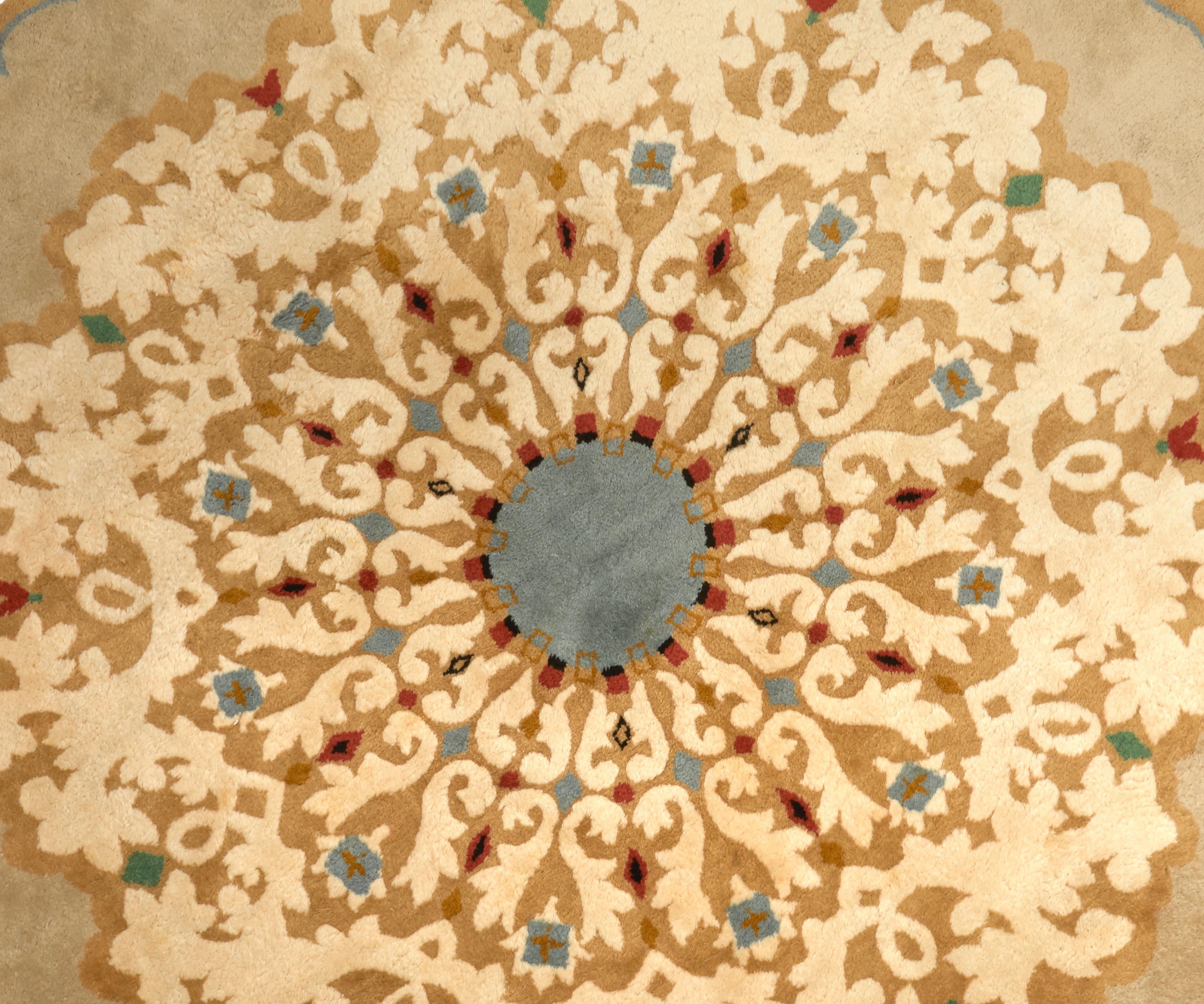 A round knotted woollen rug with sand color ground and ochre border, foliage and geometric decorations in white, green, red and blue. Not signed.