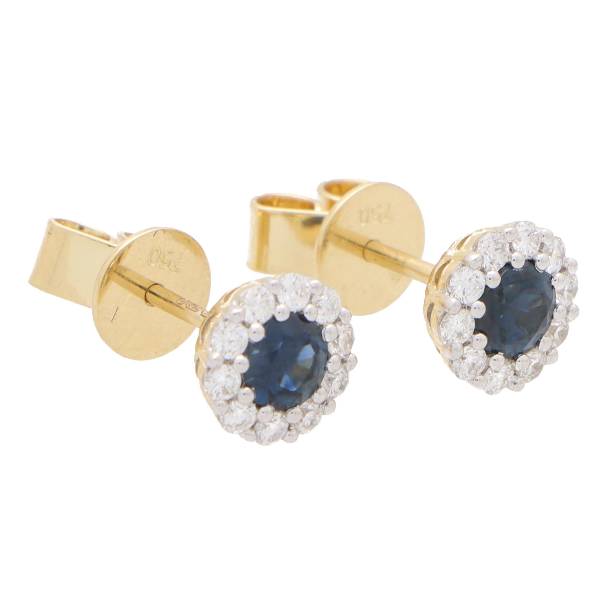A beautiful pair of sapphire and diamond circular cluster earrings set in 18k yellow gold.

Each earring centrally features a beautiful royal blue coloured round cut sapphire surrounded by a halo of 10 round brilliant-cut diamonds. All of the stones