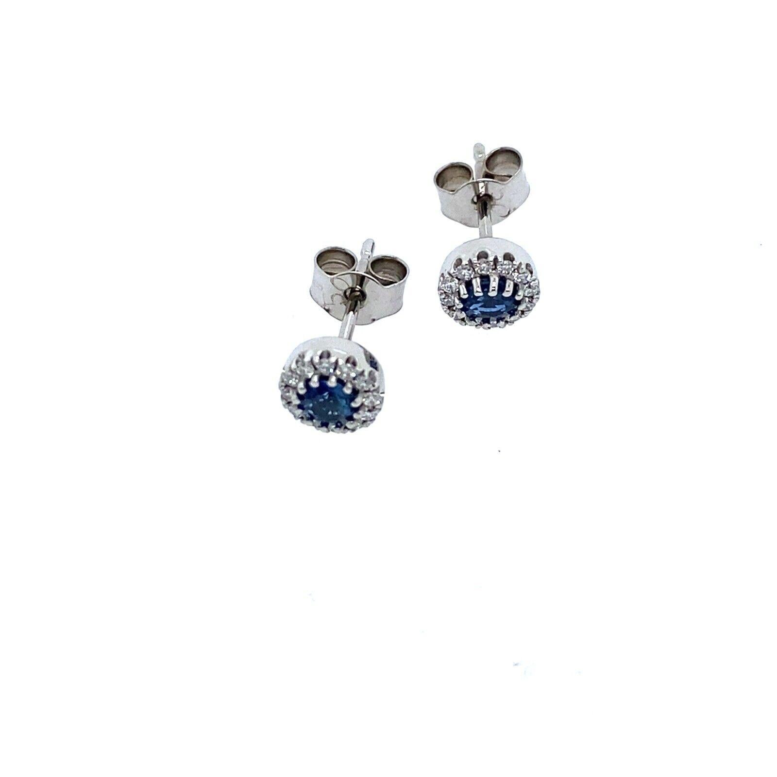 Questo paio di orecchini presenta uno zaffiro primario circondato da una splendida aureola di diamanti incastonati, per un totale di 0,16 carati, in un'incastonatura in oro bianco 18xt.Gli orecchini sono eleganti e raffinati e sono perfetti per ogni
