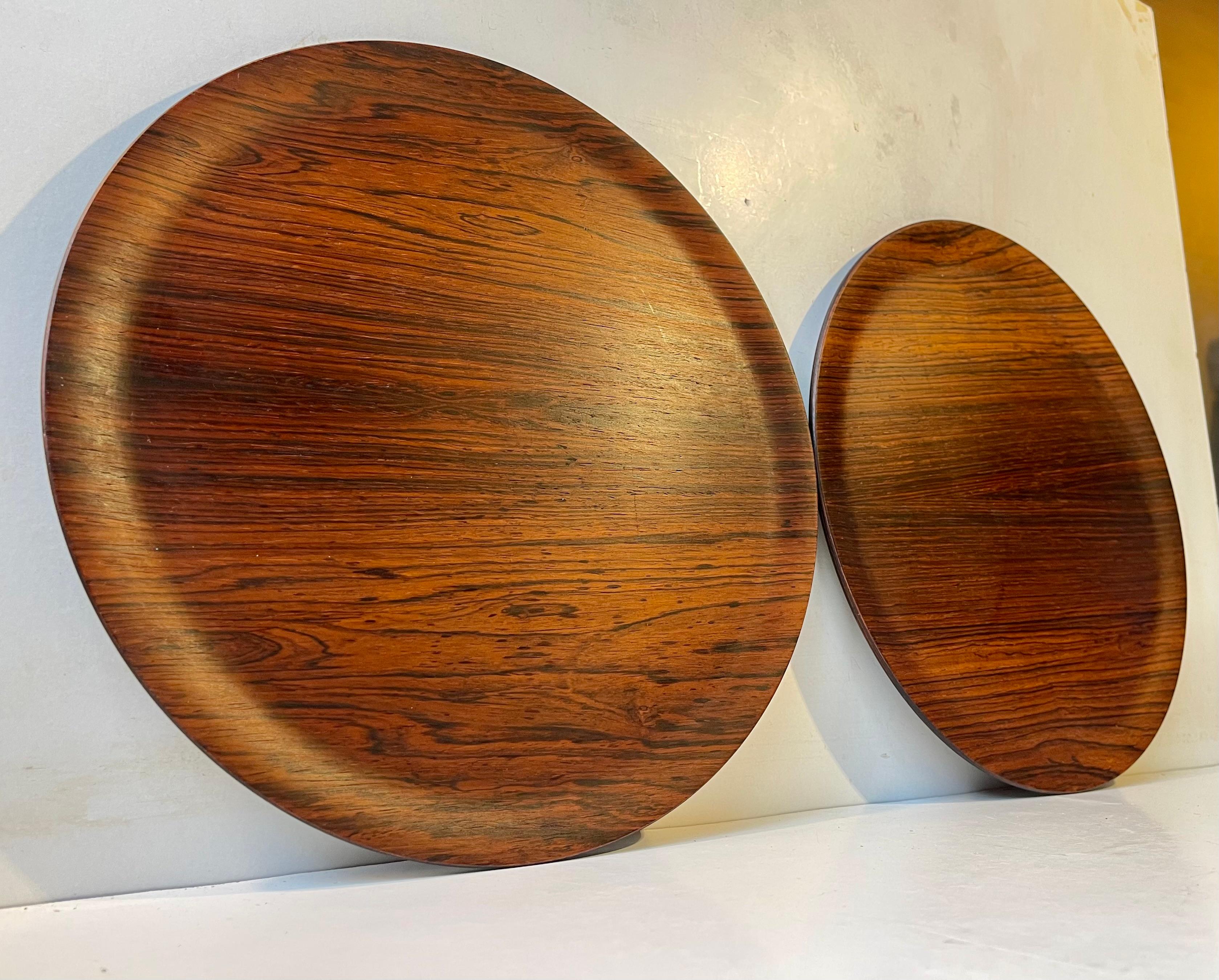 Zwei runde Getränketabletts aus geformtem/gepresstem Palisanderholz. Entworfen und hergestellt von Aaary in Dänemark in den 1960er Jahren in einem Stil, der an Henning Koppel und Uno und Osten Kristiansson erinnert. Das für diese Tabletts verwendete