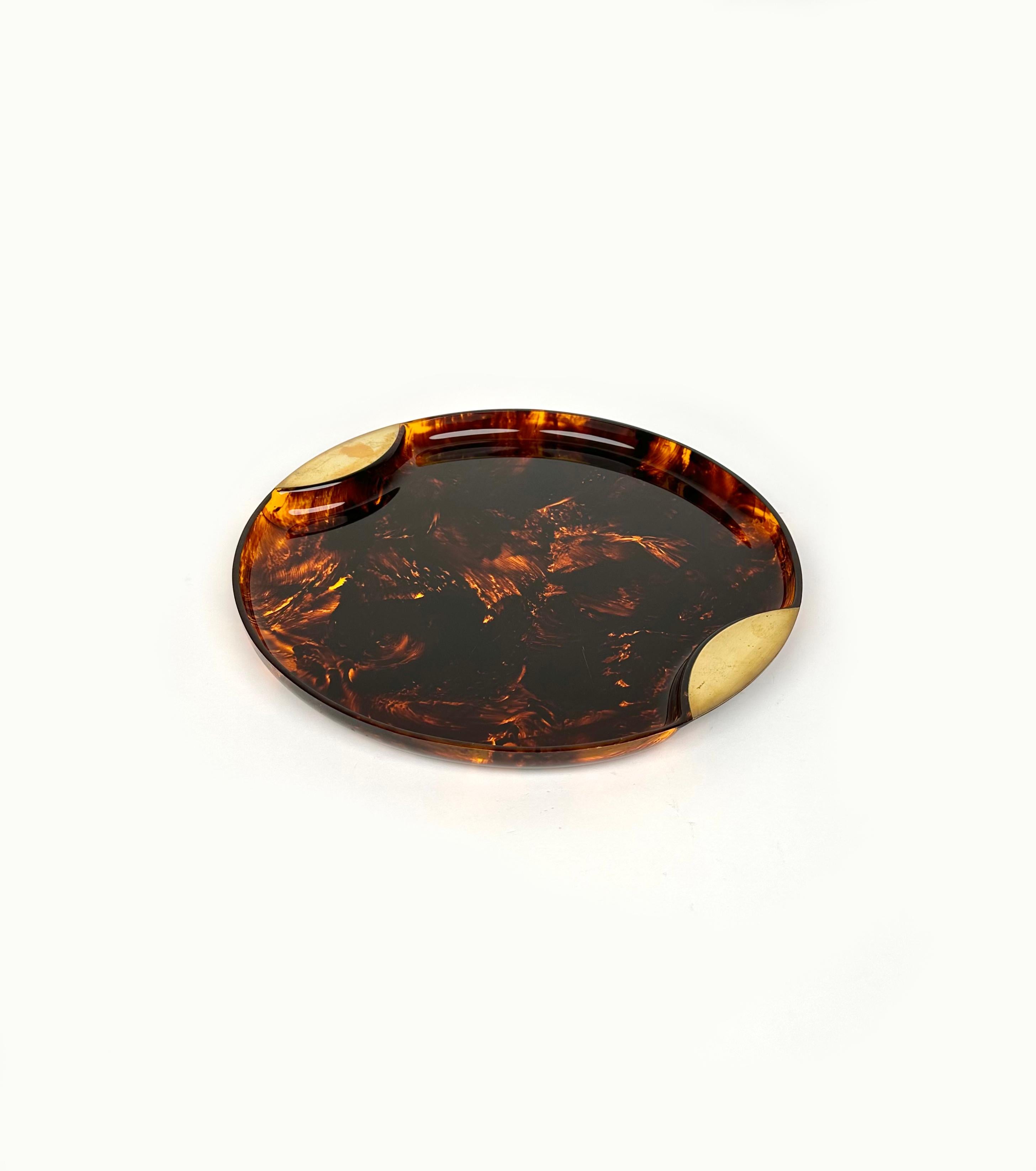 Amazing round serving tray or centerpiece in lucite faux tortoiseshell effect and brass handles, attributed to Guzzini. 

Made in Italy in the 1970s.