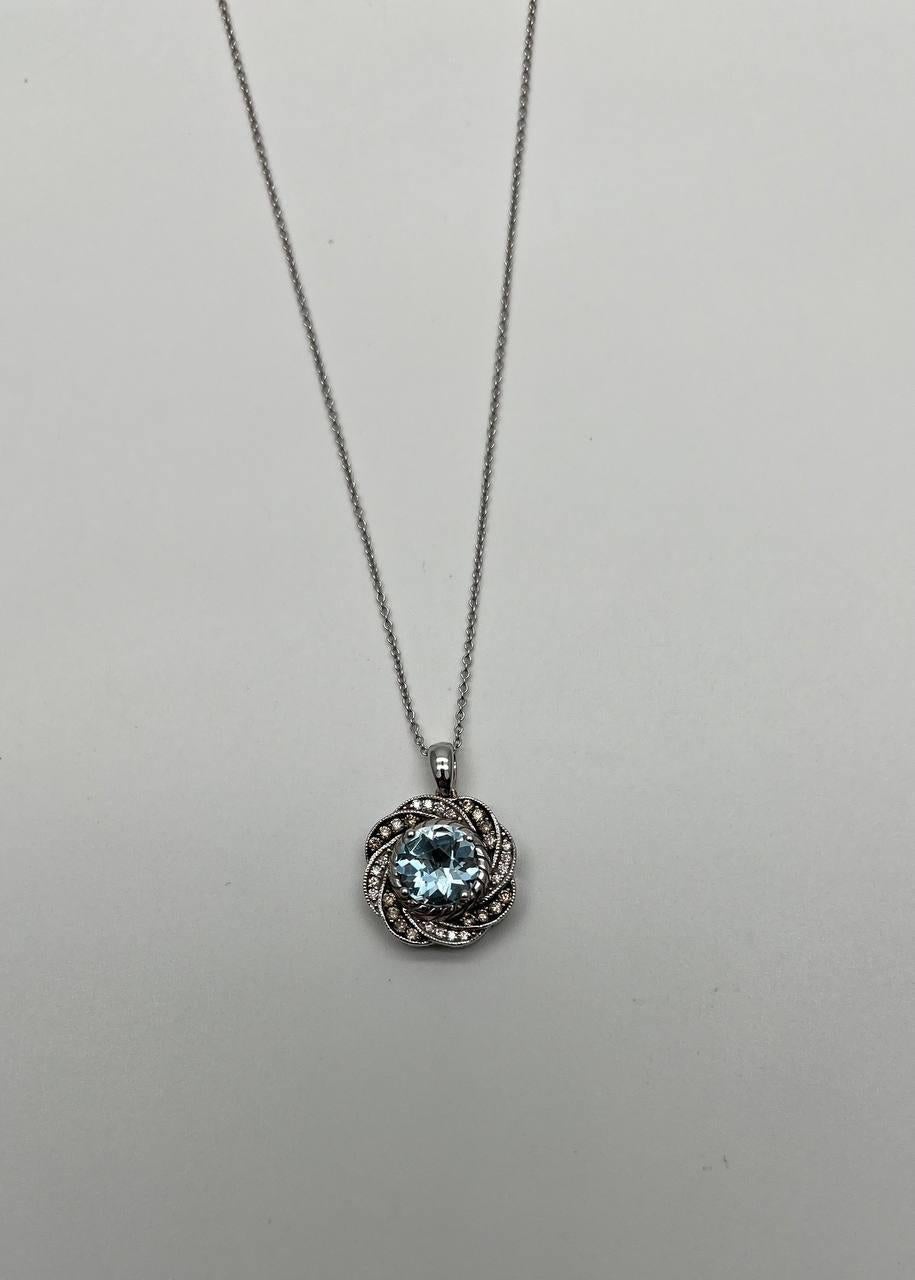 A captivating pendant necklace, featuring a central round-cut blue aquamarine encircled by an intricate twisted design adorned with smaller diamonds. The pendant is suspended from a delicate chain, showcasing a harmonious blend of elegance and