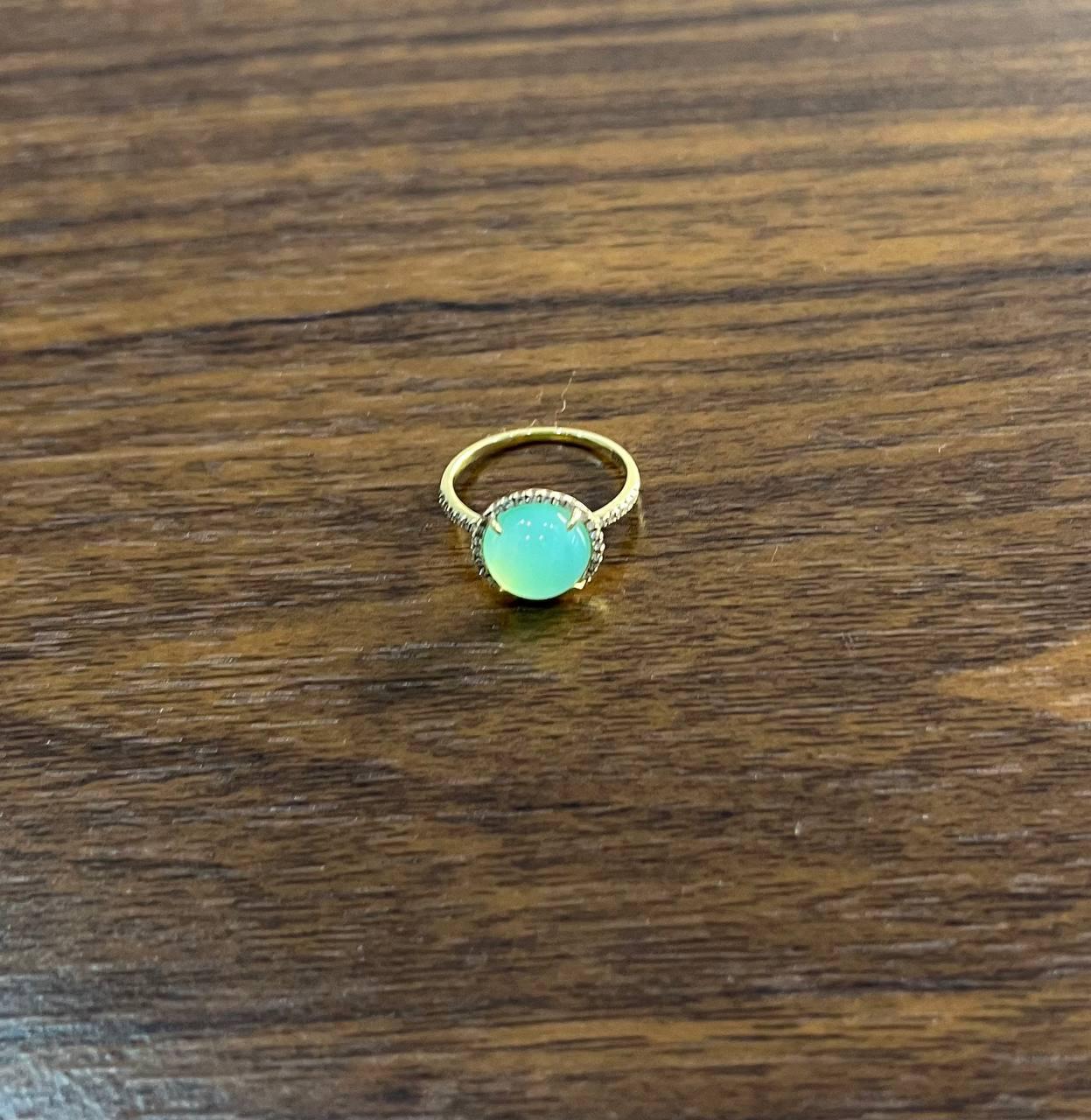 A striking Aquamarine and Diamond Ring, featuring a captivating round green Aquamarine set in 14k Yellow Gold, elegantly accented with white Diamonds. 10MM Aquamarine.