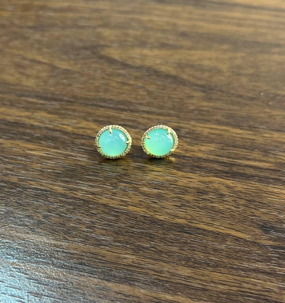 Este exquisito par de pendientes está elaborado en oro de 14 quilates. Los pendientes llevan piedras de aguamarina verde de talla redonda con un cautivador tono verde. El diseño es sencillo pero sofisticado, resaltando la belleza de las piedras.