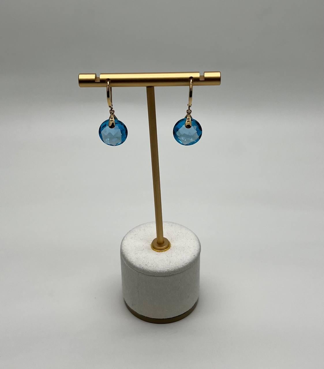 These contemporary earrings feature striking blue faceted Swiss Blue Topaz. Each earring is adorned with a teardrop-shaped accent encrusted with small, sparkling diamonds. 
14K Yellow Gold. 
0.31 CTW Diamonds 
6.84 CTW Swiss Blue Topaz