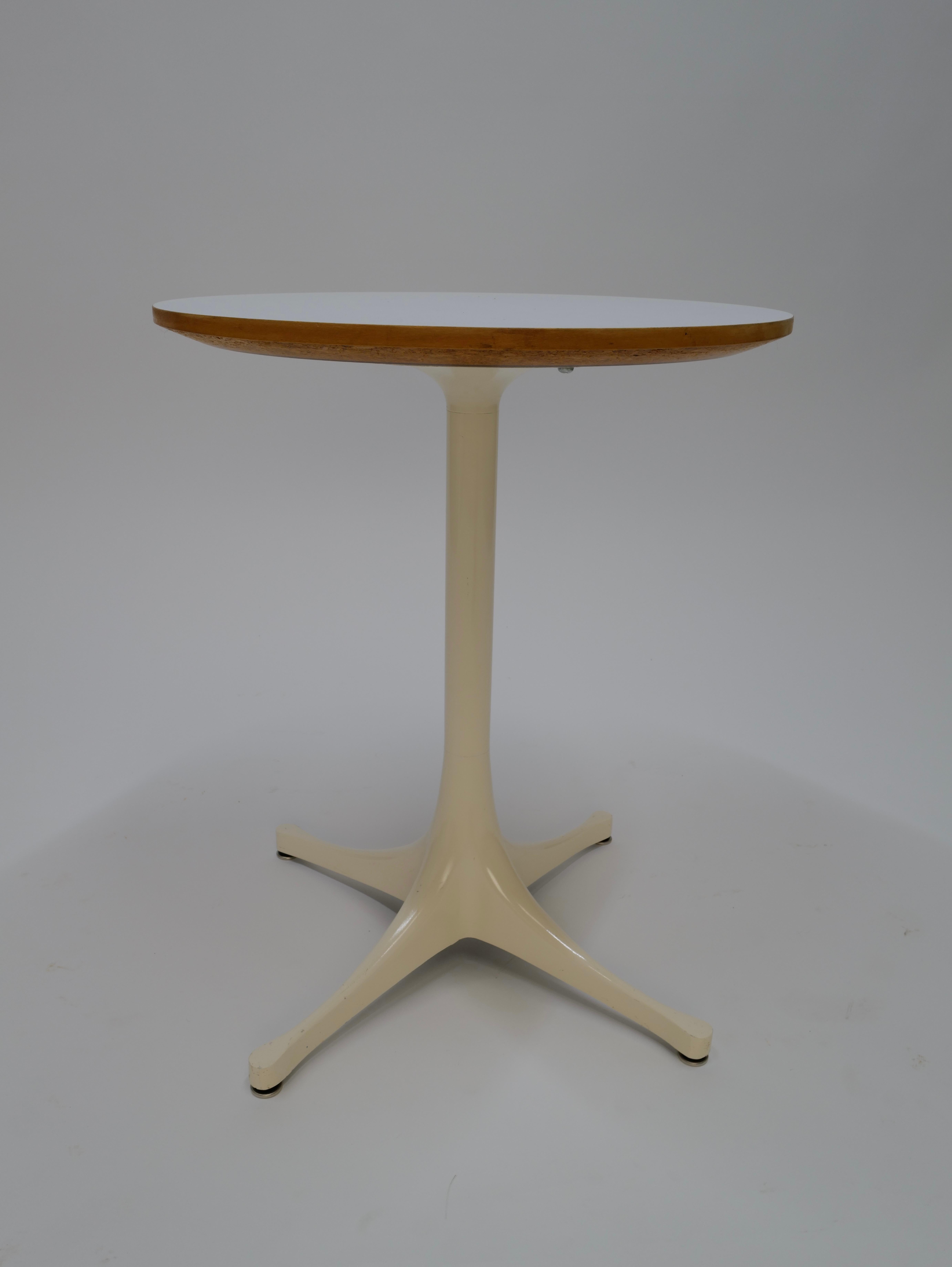The George Nelson-designed round pedestal side table for Herman Miller features a timeless and sleek design. Crafted with meticulous attention to detail, it boasts a circular table surface supported by a slender pedestal base. The combination of