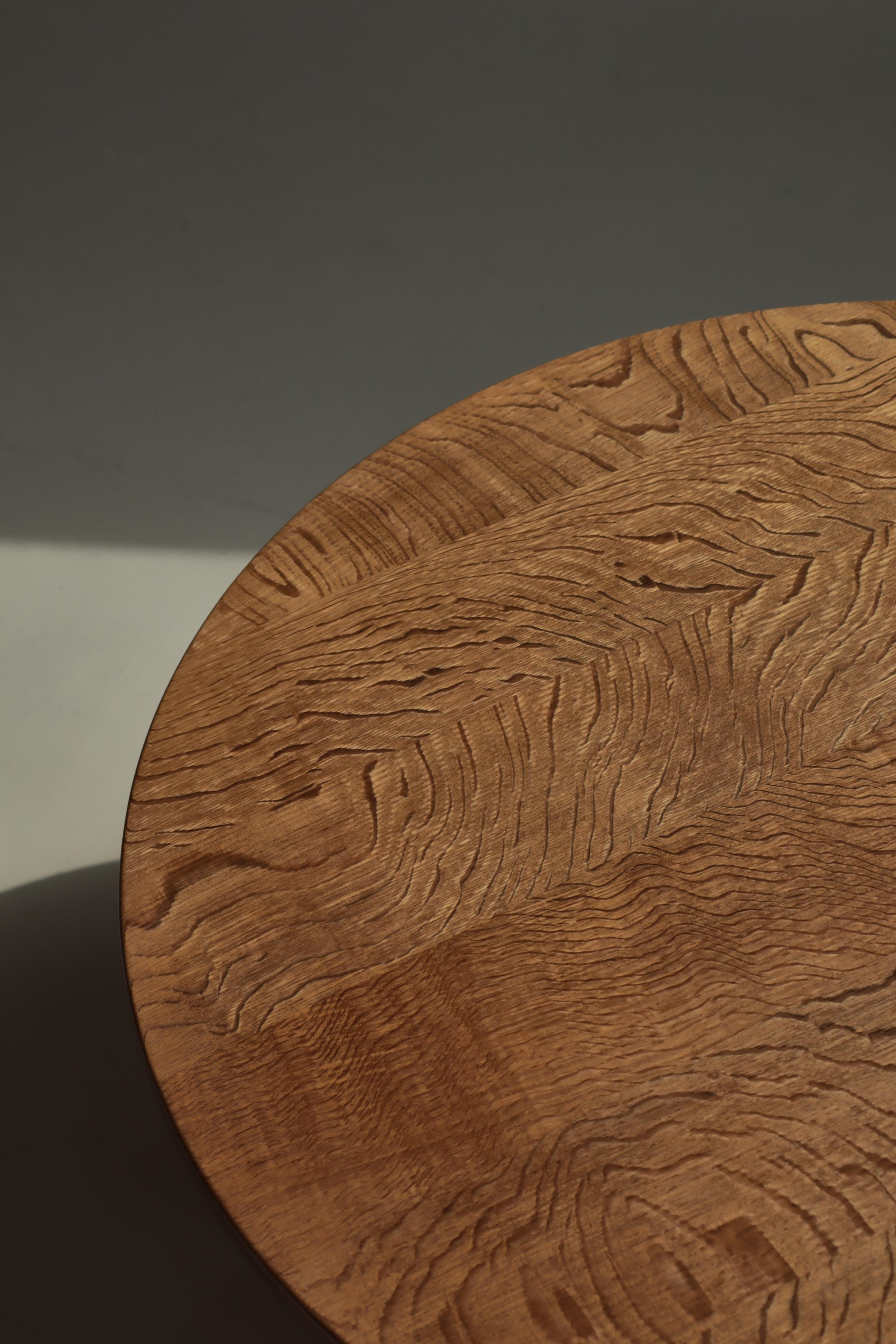 Round side table in solid quarter sawn oak with a beautiful wood grain. The table was made in Denmark in the 1960s and is attributed to Henning Kjærnulf. The table is solid and sturdy and mixes modern virtues with hints to baroque style, which is