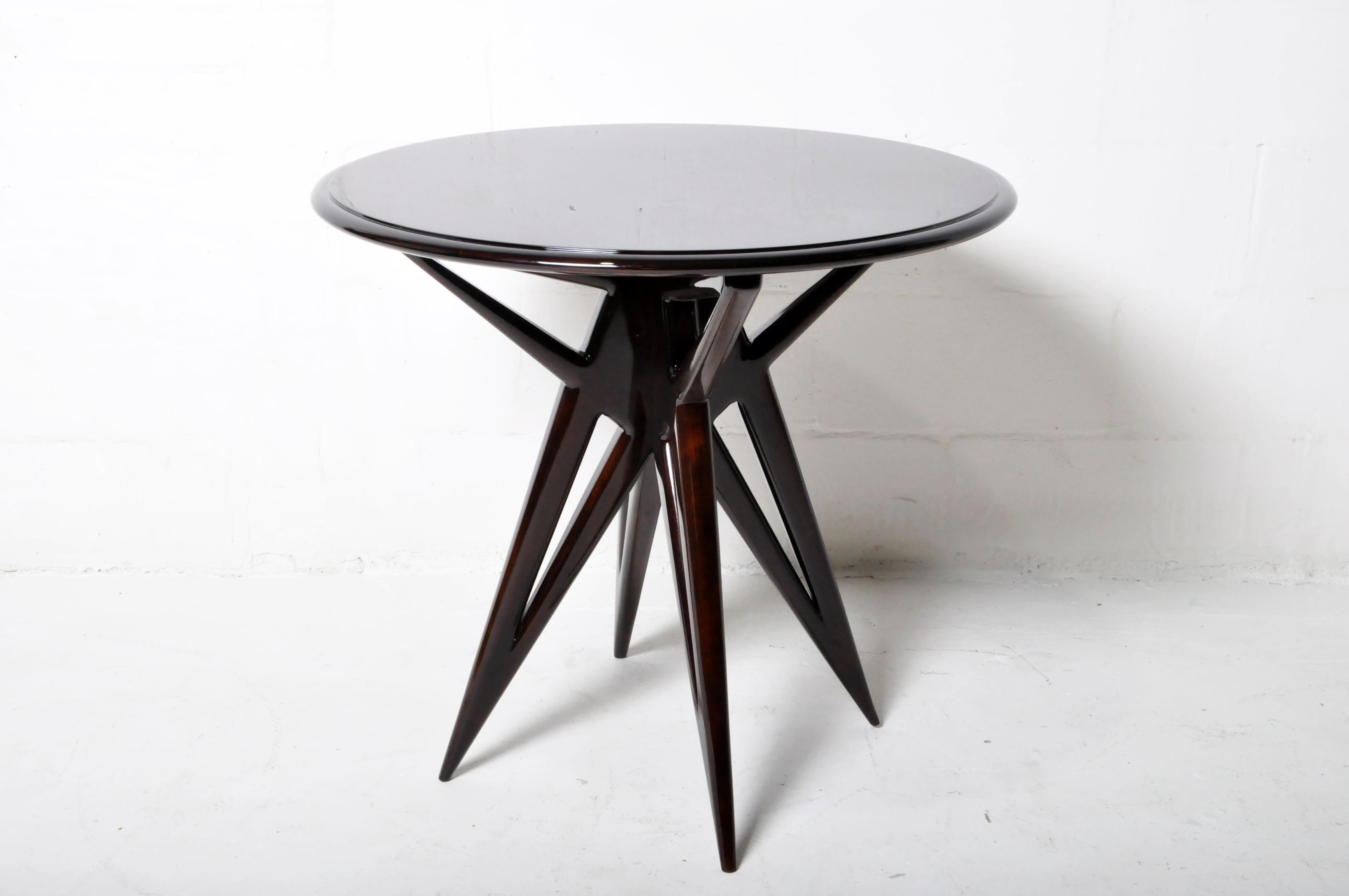 This strikingly angular table has solid hardwood legs holding up a round top with pie-shaped, book-matched walnut veneers.