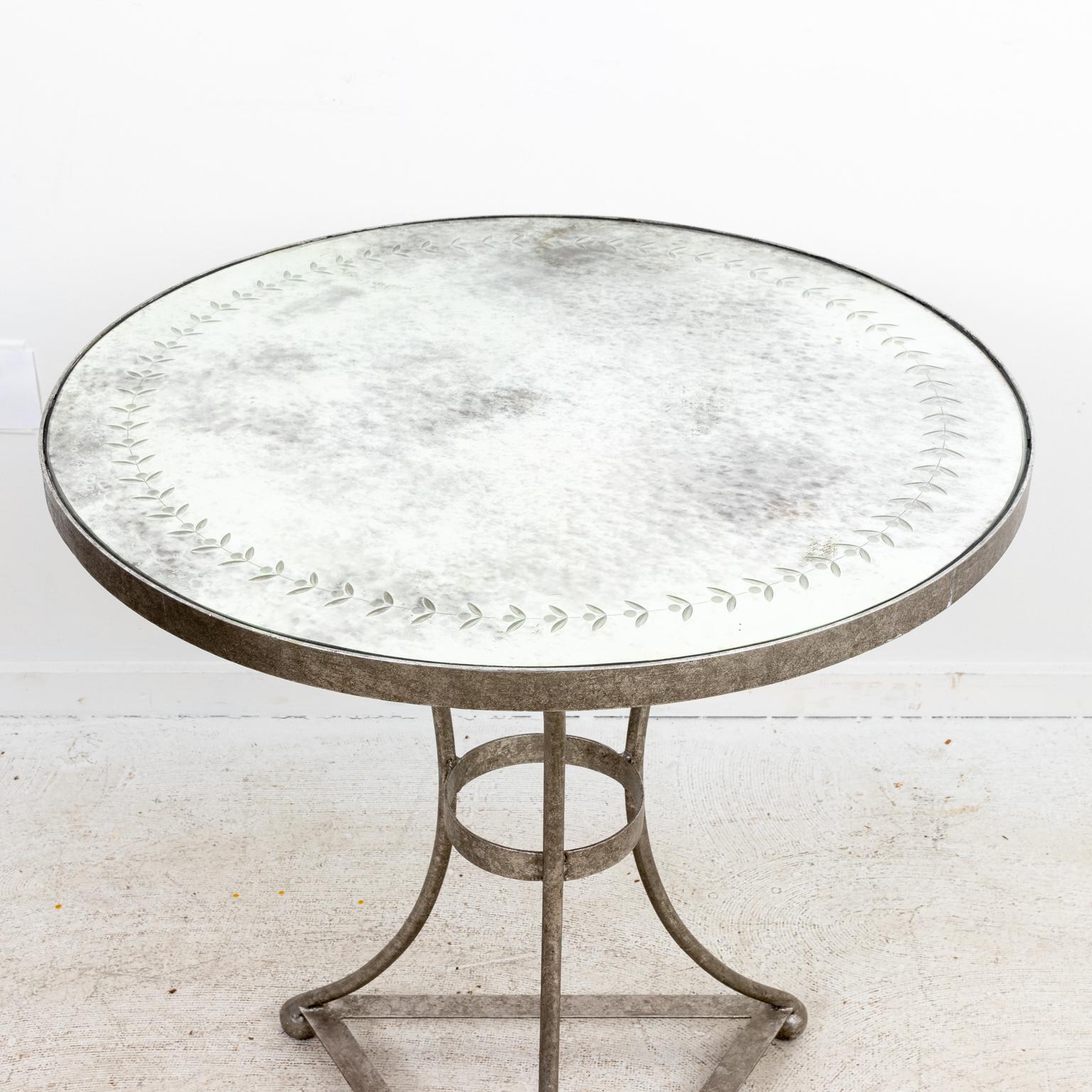 Round side table with Mercury mirror tabletop and silver gilt base. The tabletop is also detailed with laurel trim. Please note of wear consistent with age including patina and oxidation.