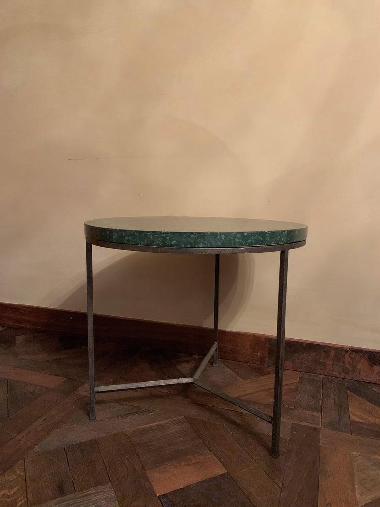 A round occasional table with a 19th century serpentine veneered top on a contemporary base. The top skillfully inlayed with intarsia in a clover decoration the base custom designed by our workshop and executed in hand forged iron. Finished with a