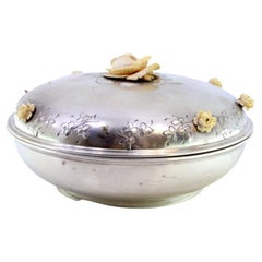 Runde silberne Bonbondose mit floralem Relief auf dem Deckel und blumenförmigem Griff