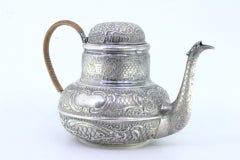 Round silver kettle with reliefs, monogram panels and coated handle