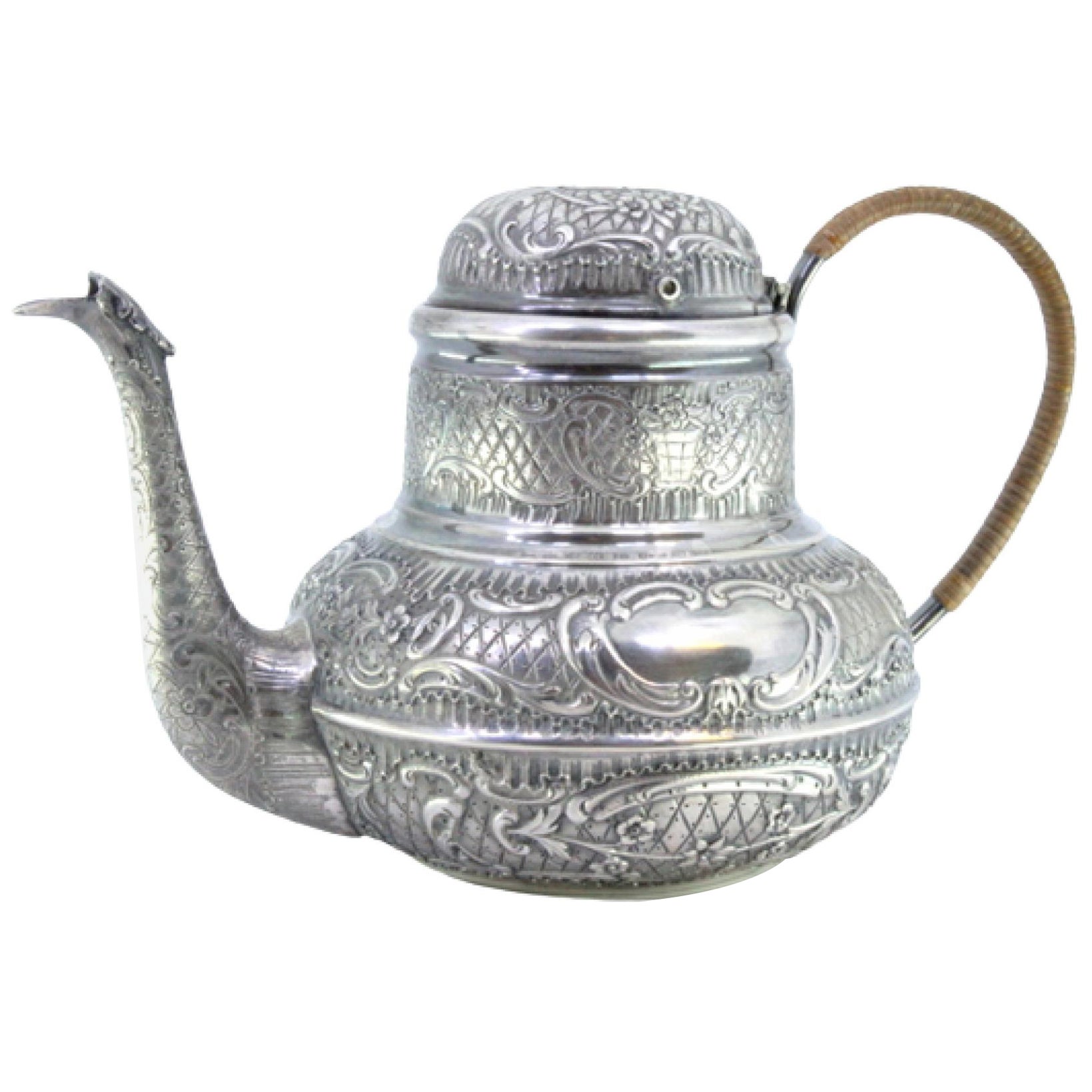 Round silver kettle with reliefs, monogram panels and coated handle