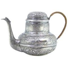 Round silver kettle with reliefs, monogram panels and coated handle