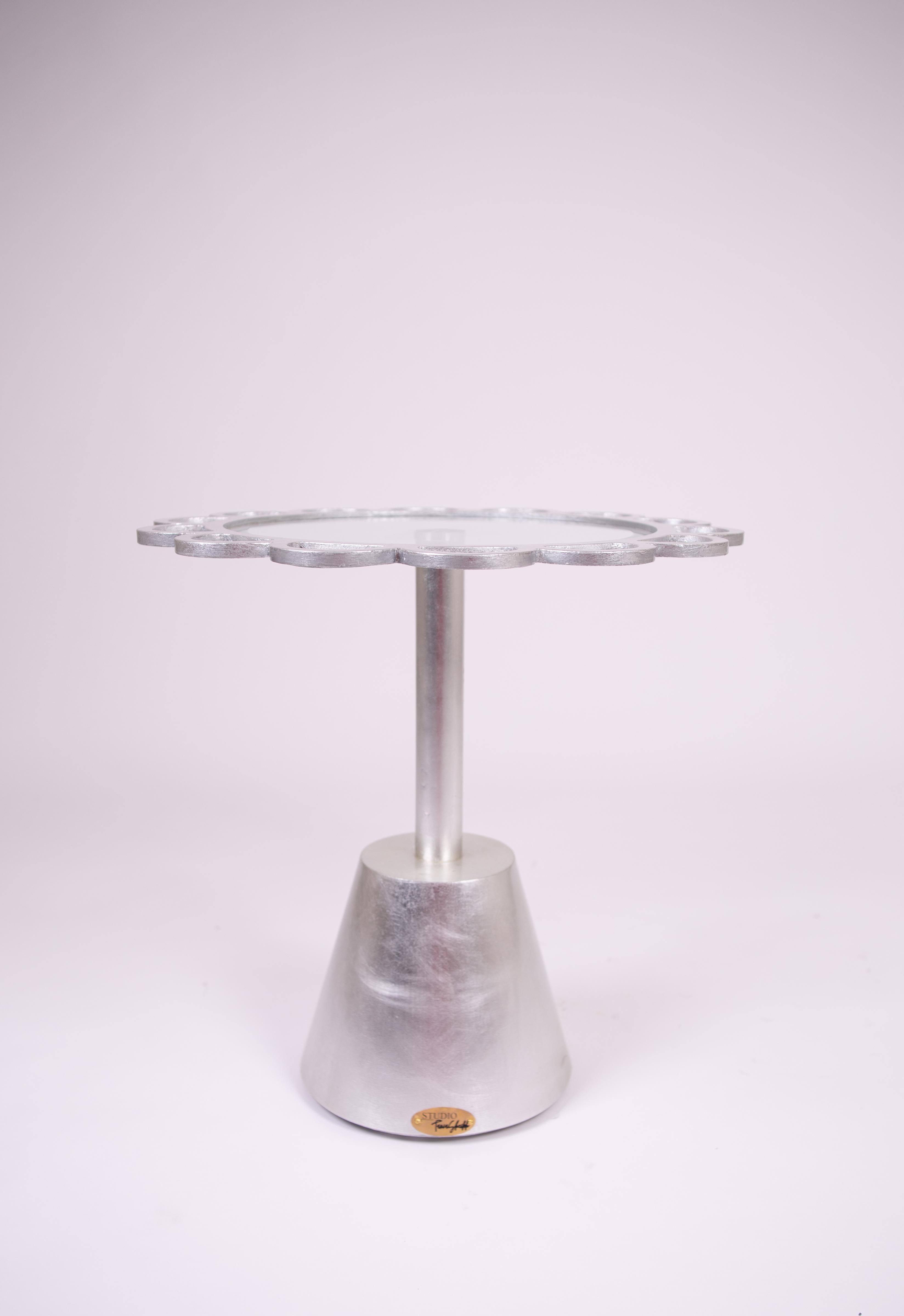 La mesa auxiliar Silver Leaf es una pieza de acento de lujo diseñada para elevar cualquier espacio con una elegancia atemporal. Con una estructura redonda de metal con bordes festoneados únicos, esta mesa de centro plateada está acabada en un rico