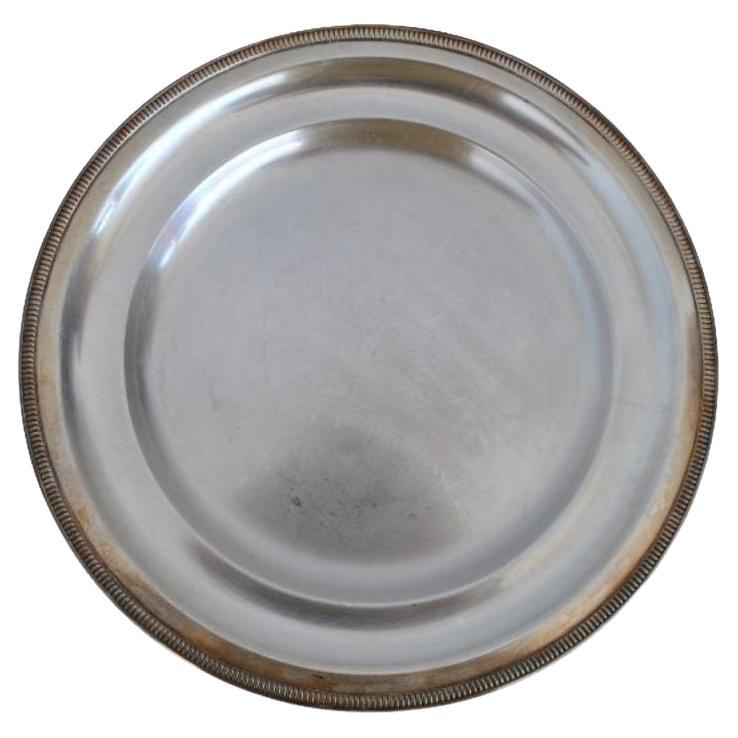 Plat rond en métal argenté signé Ubner