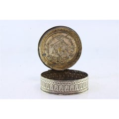 Round silver pill box with relief dove of peace between bows and garlands