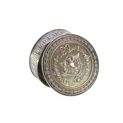 Round silver pill box with relief dove of peace between bows and garlands