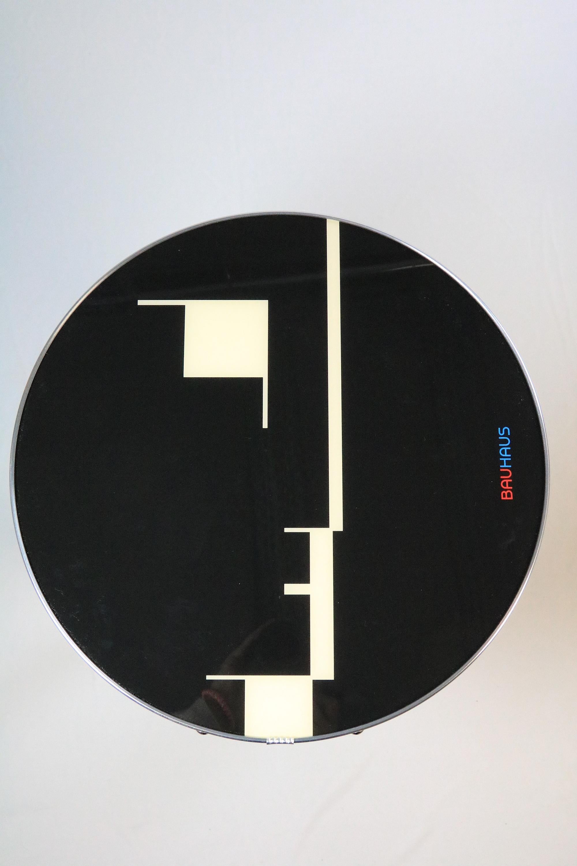 Esta mesa versátil y muy decorativa es una combinación de Bauhaus y diseño contemporáneo. Fue diseñada por nosotros y producida con un alto nivel de calidad en talleres locales de Berlín. El acabado, como el atractivo ribete plateado y las patas de
